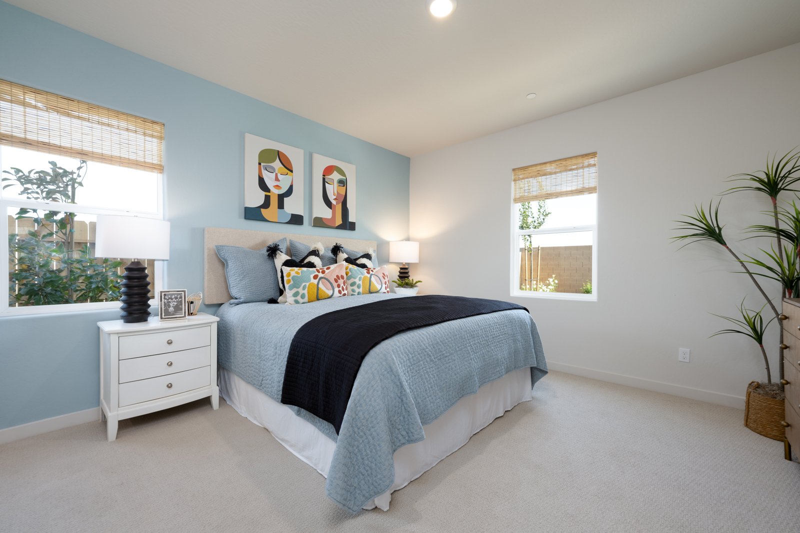 A bedroom with a bed and a plant.