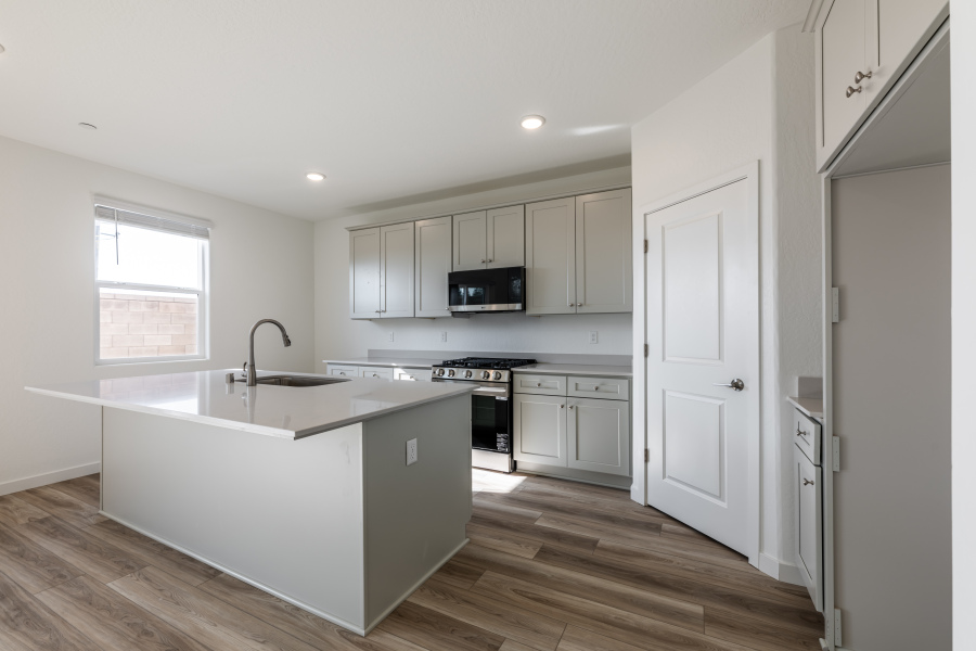 A kitchen with white cabinets.