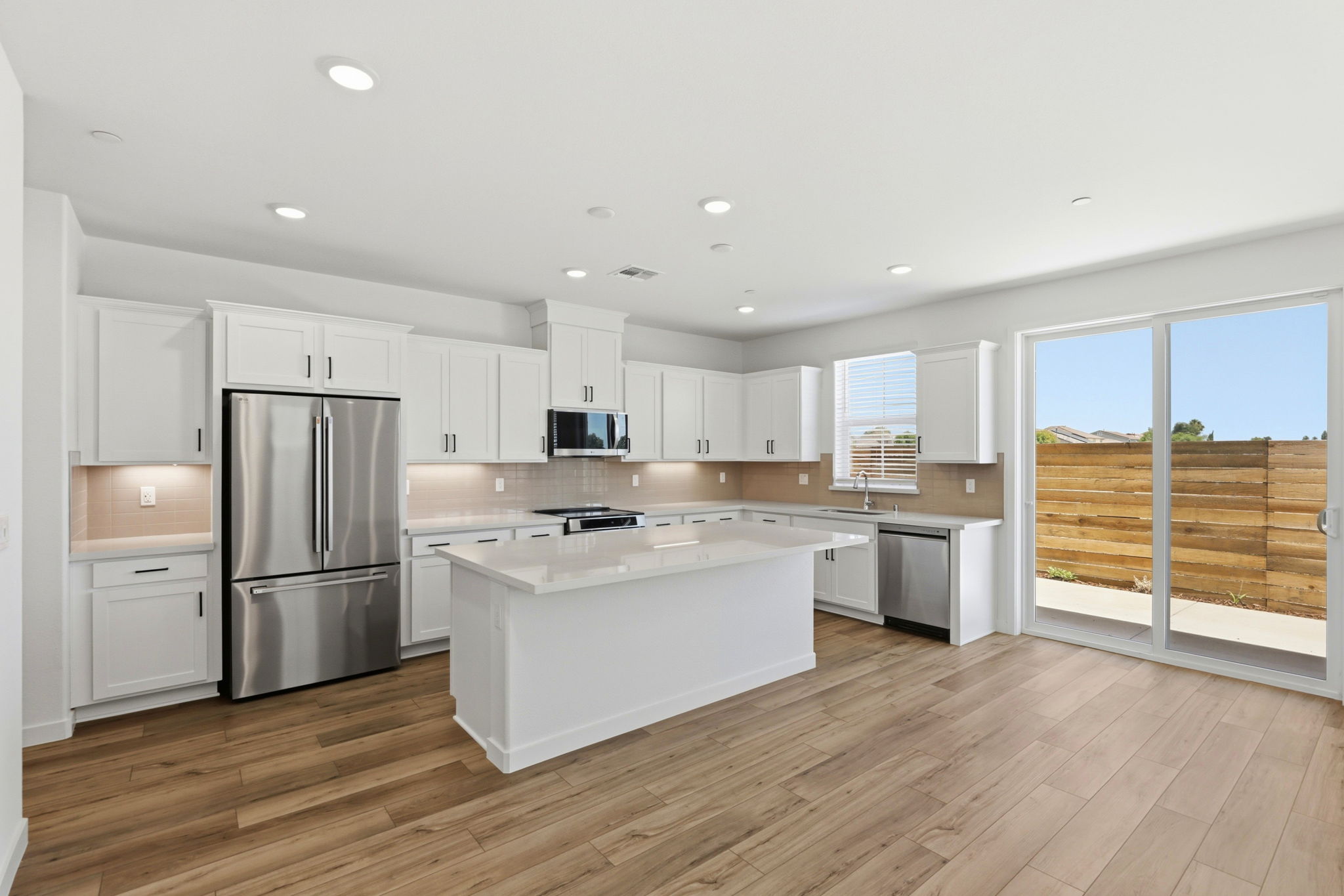 A kitchen with white cabinets.