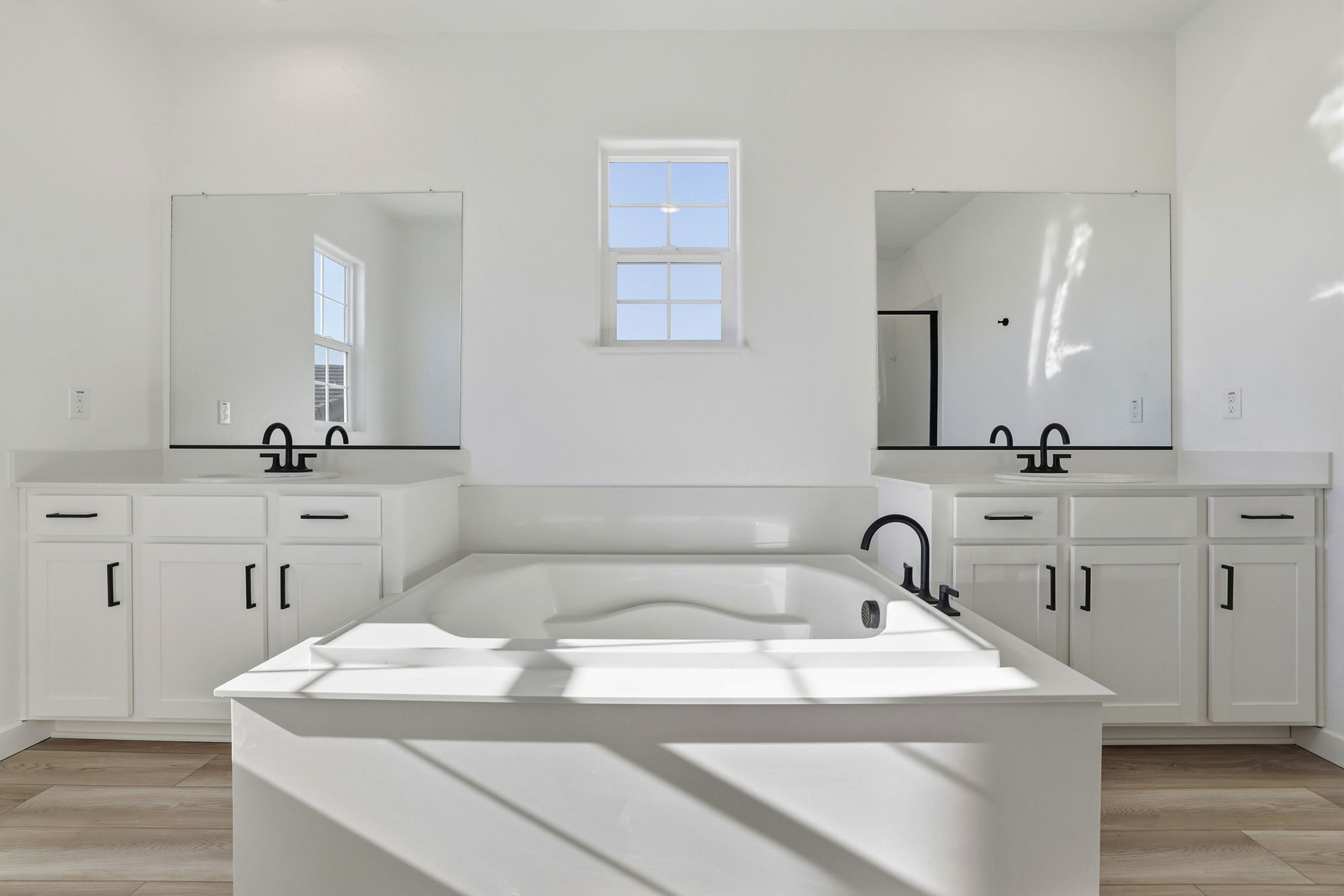 A white bathroom with a tub and sink.
