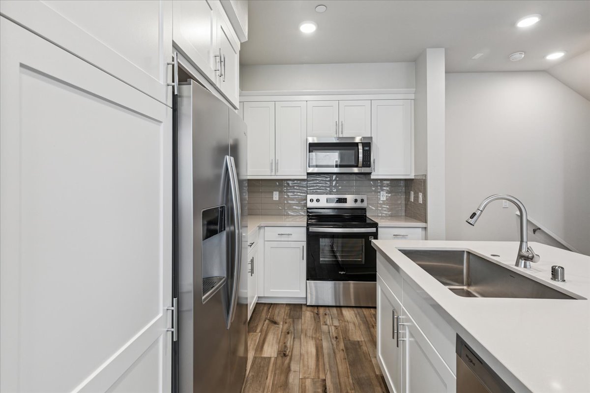 A kitchen with white cabinets.