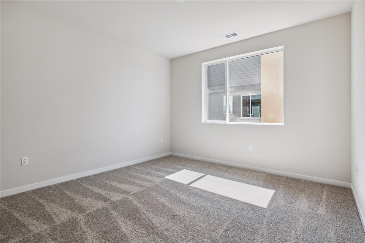 A room with a rug and a window.