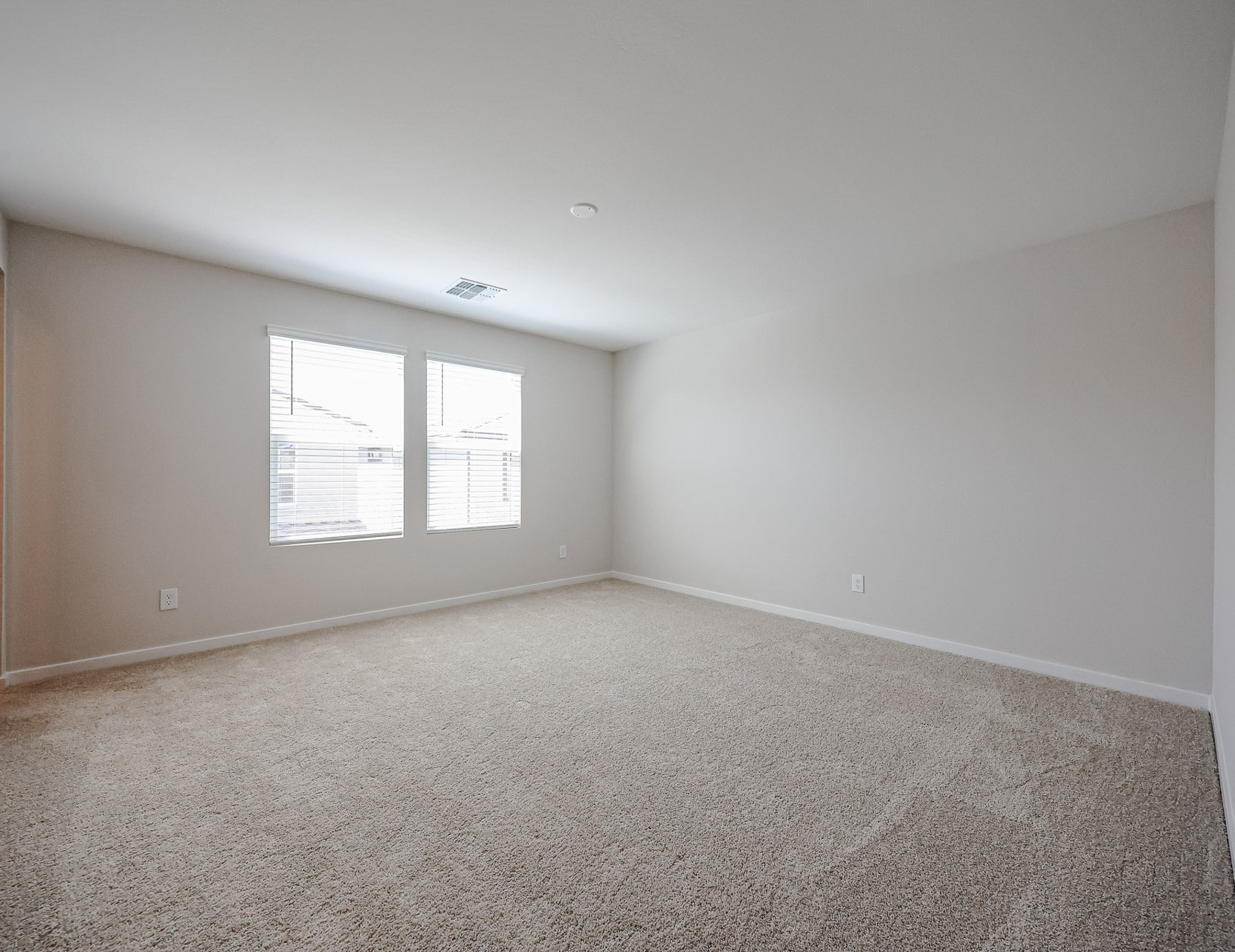 A room with a carpet and windows.