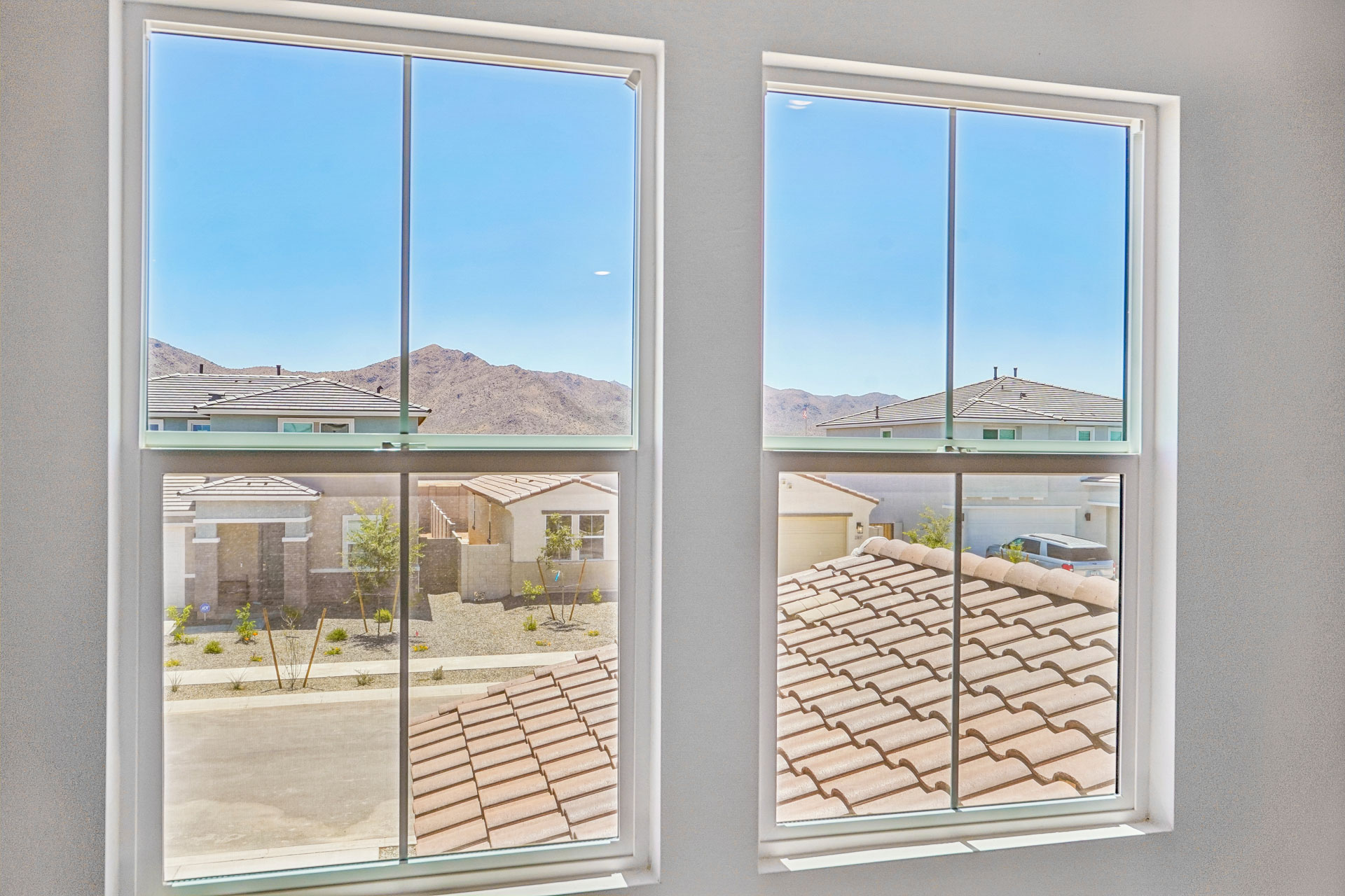 A group of windows with a view of a town and mountains.