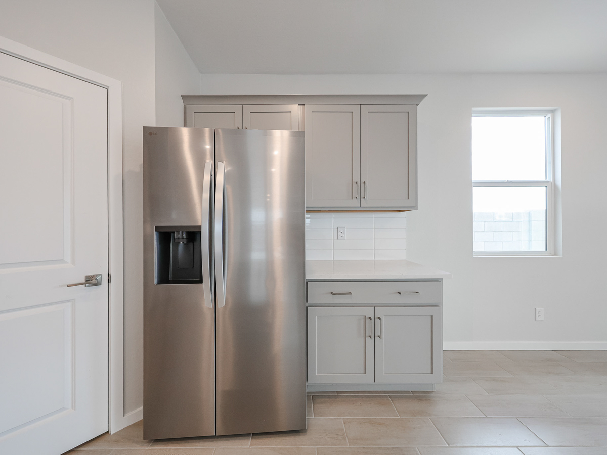 A kitchen with white cabinets.