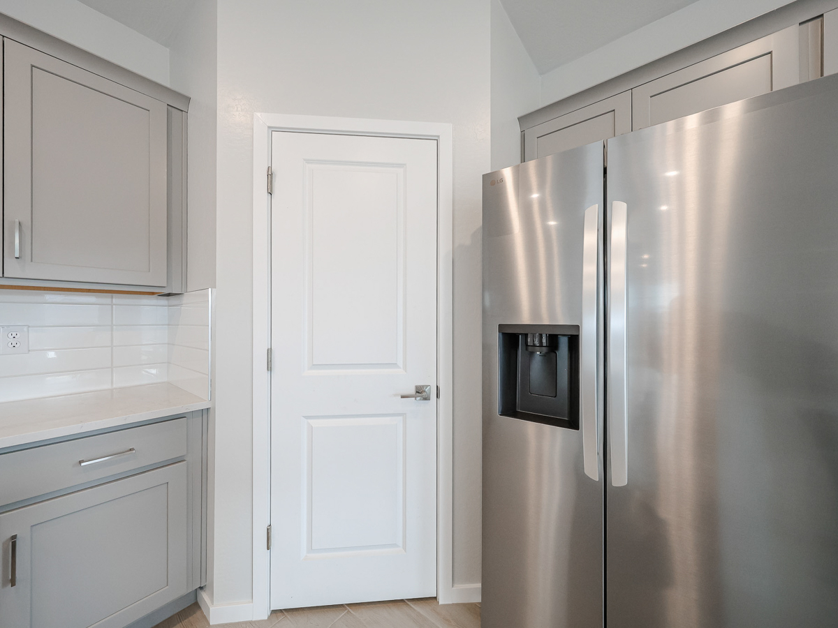 A kitchen with white cabinets.