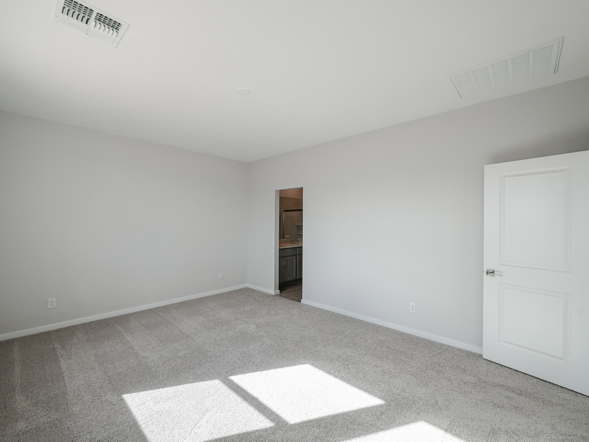 A room with a white door and a white wall.