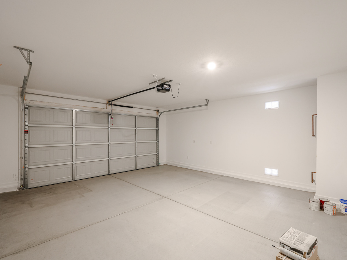 A room with a large white wall and a metal object on the ceiling.
