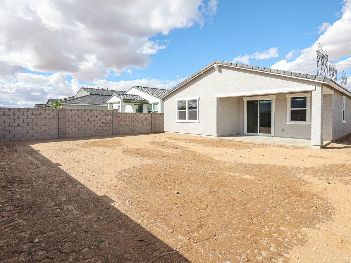 A dirt road leading to a house.