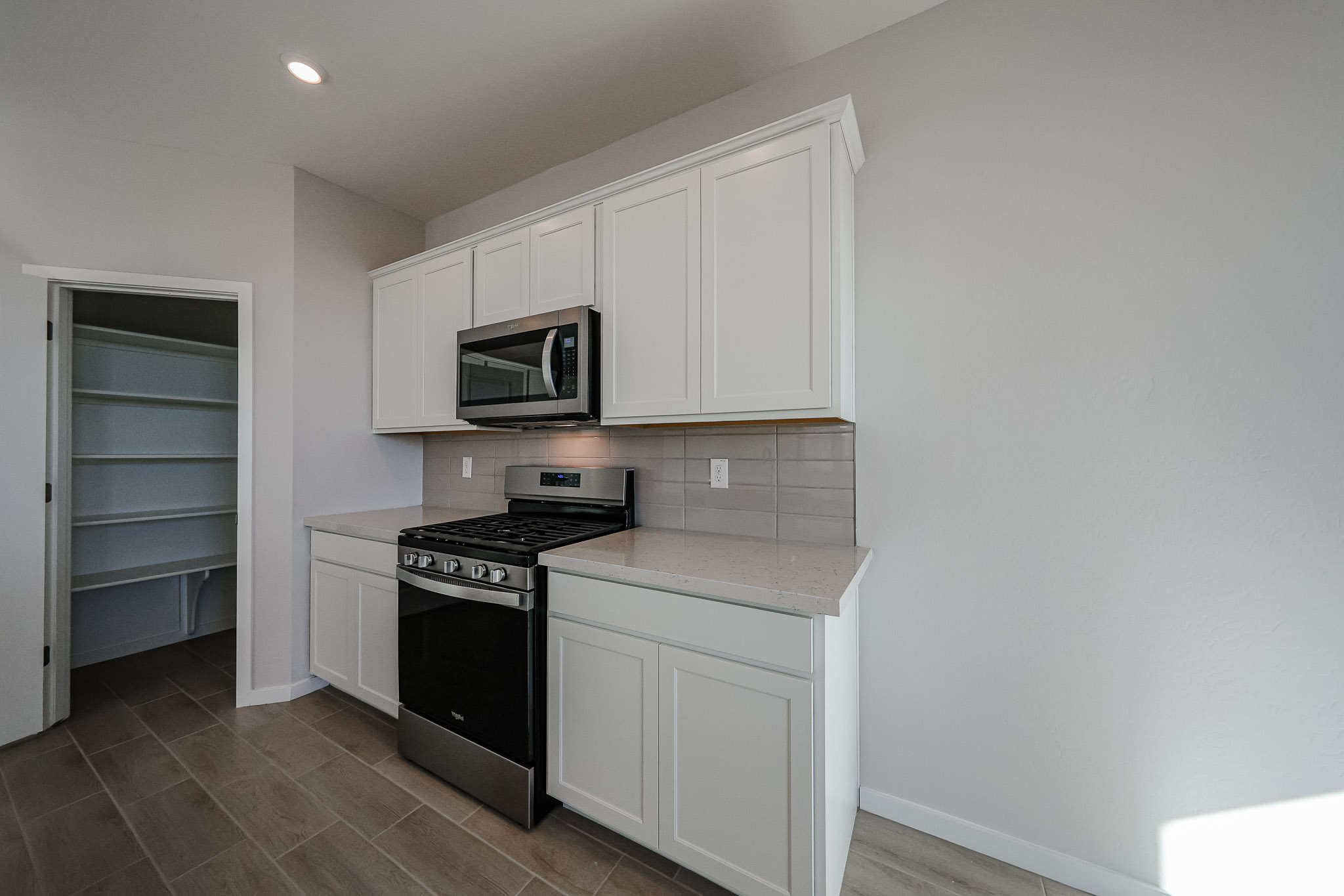 A kitchen with white cabinets.