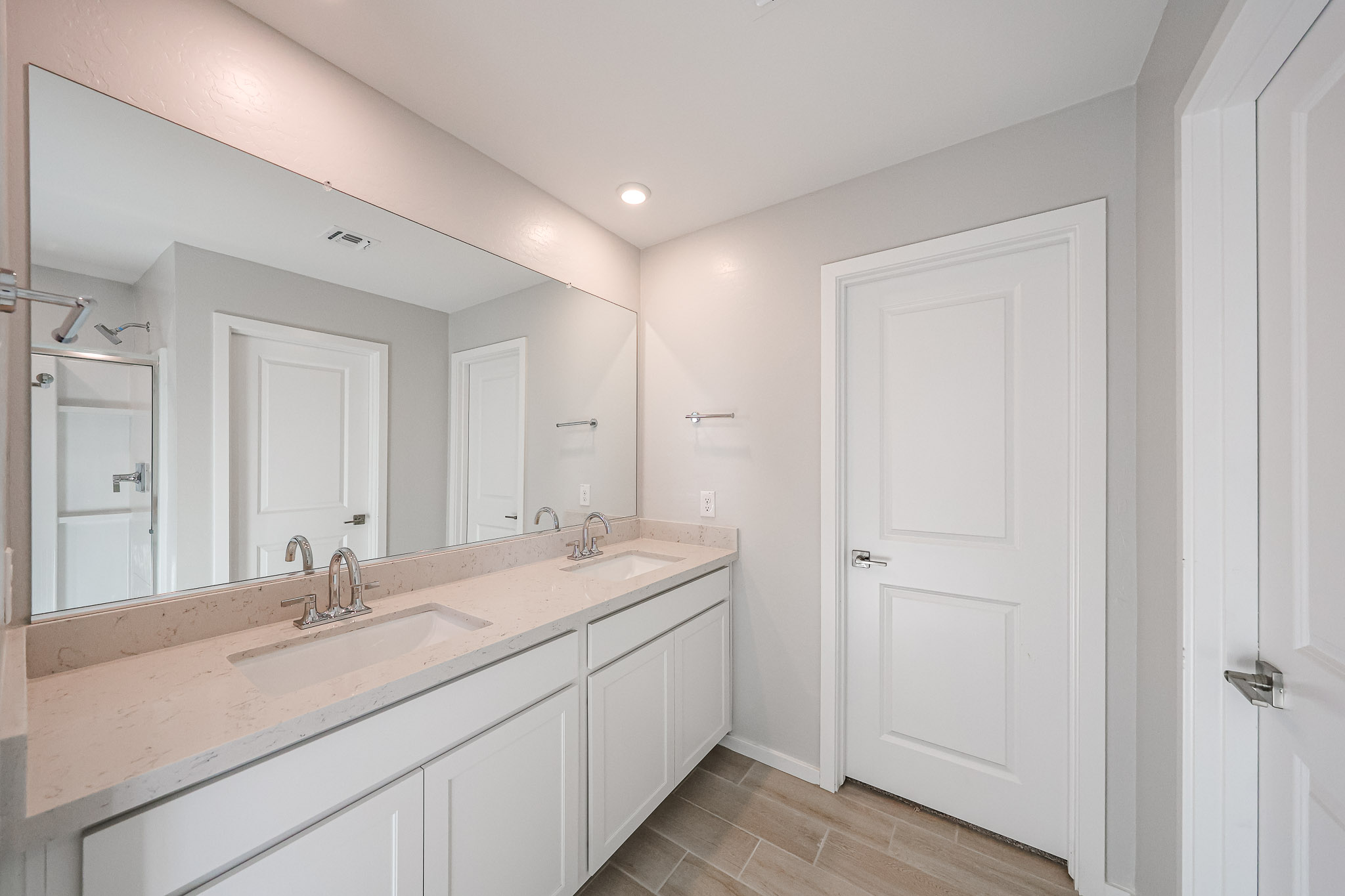 A bathroom with a large mirror.