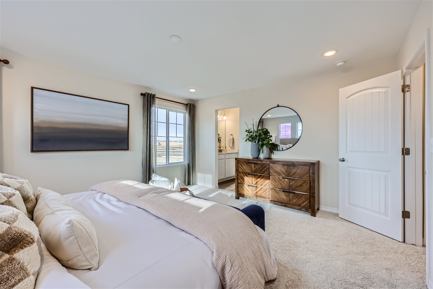 A bedroom with a bed and a mirror.