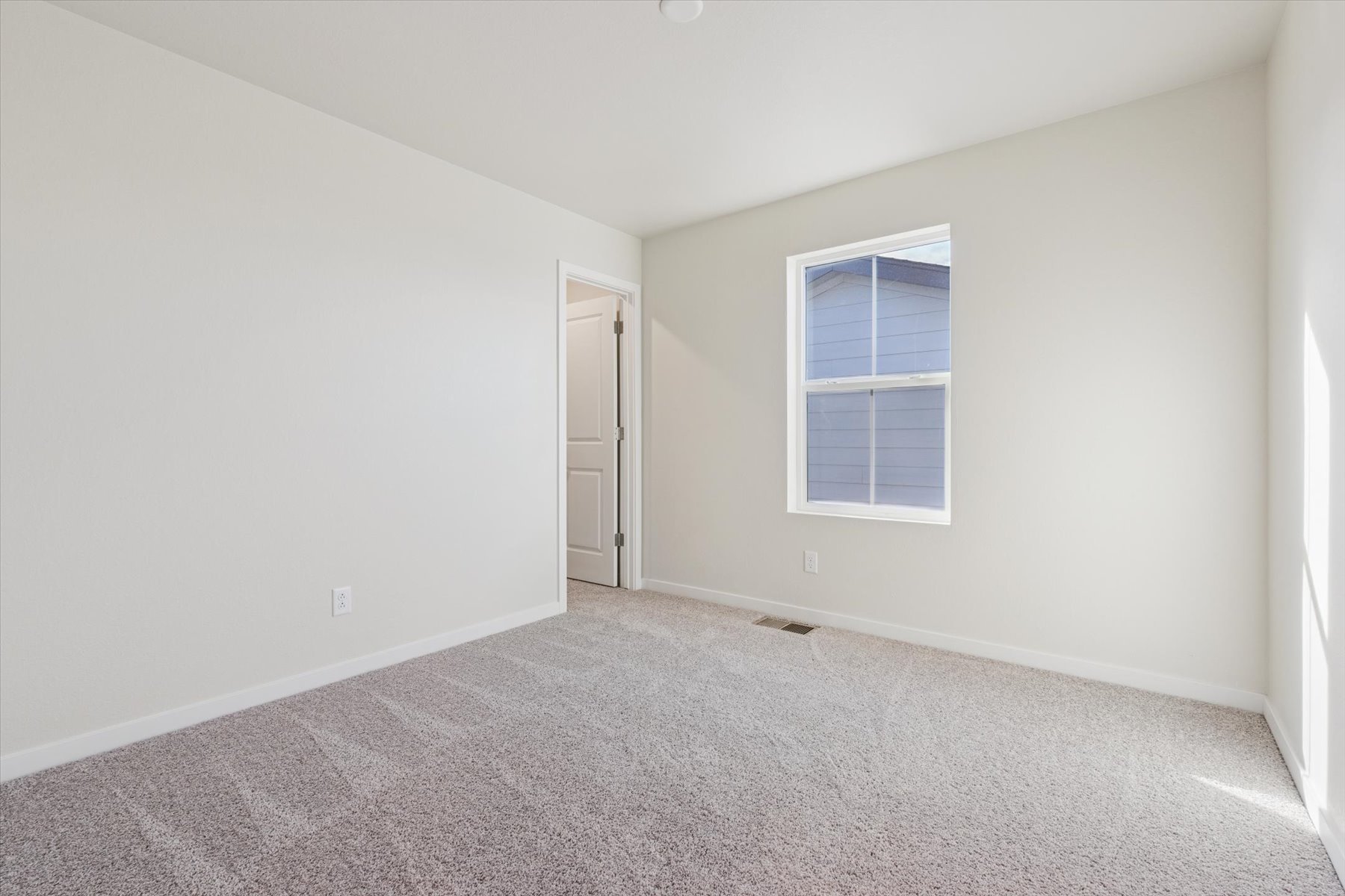 A room with a carpet and a door.