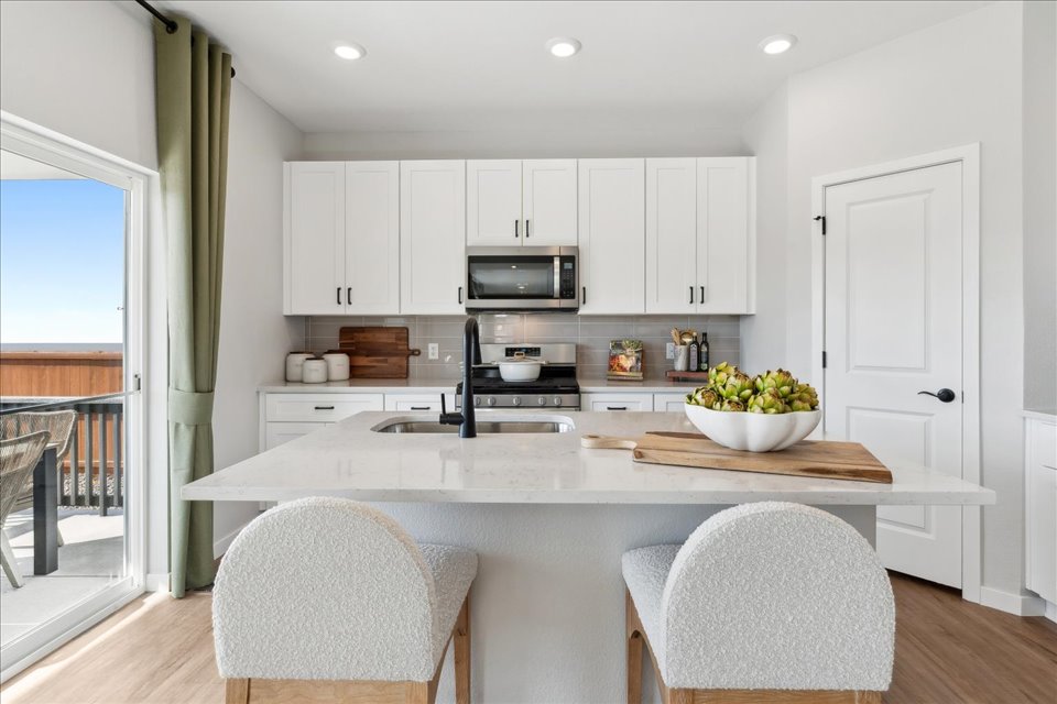 A kitchen with white cabinets.