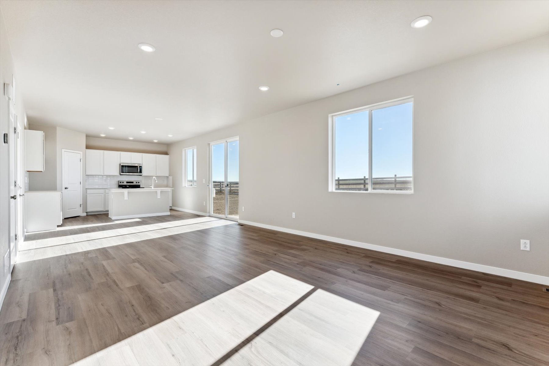 A large empty room with a wood floor and a wood floor.