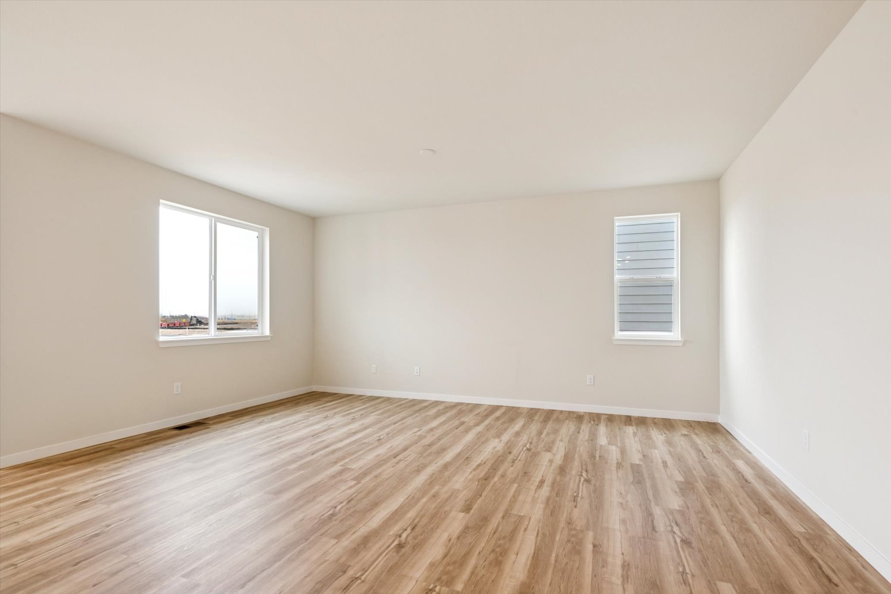 A room with a wood floor and windows.