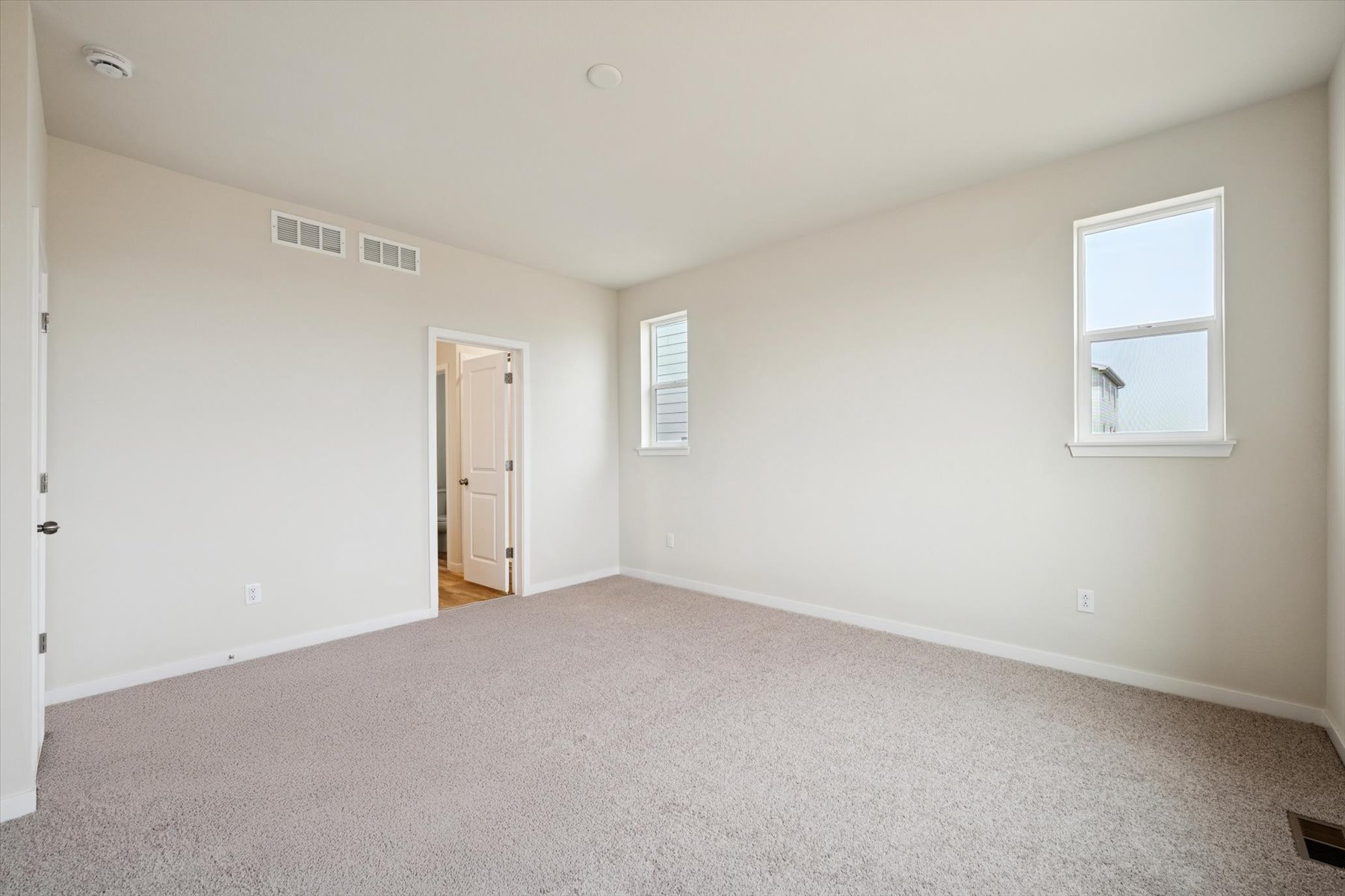 A room with a carpet and a door.