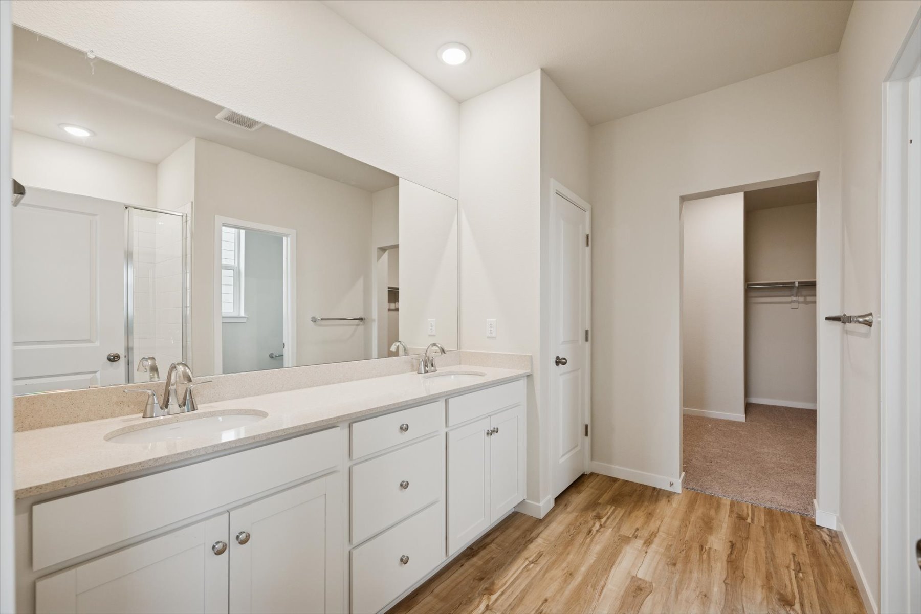 A bathroom with white cabinets.