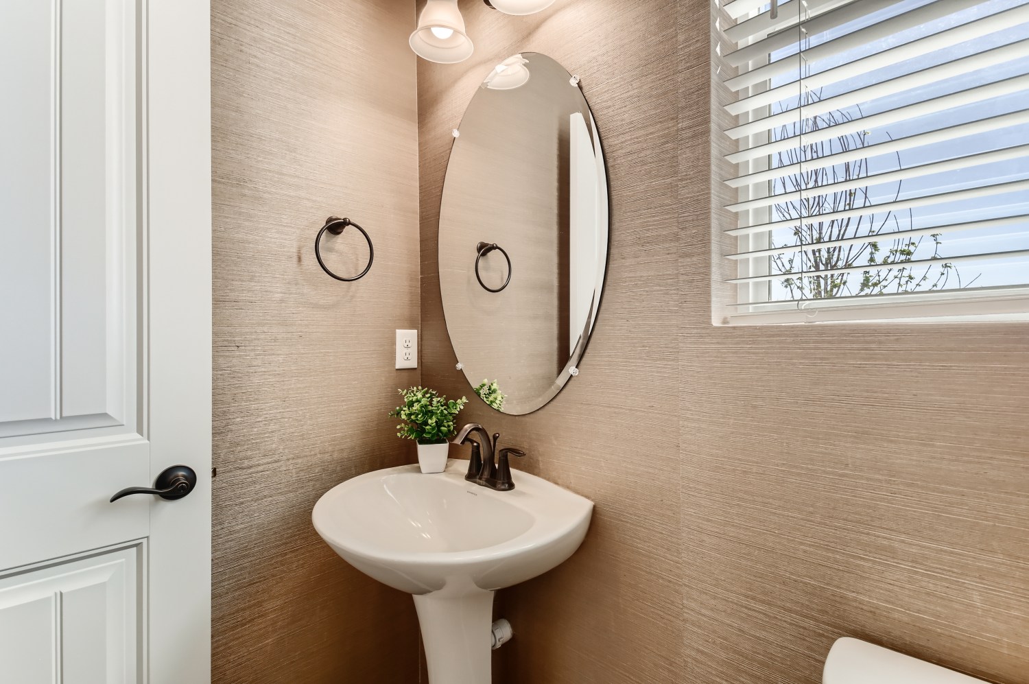 A bathroom with a round mirror.