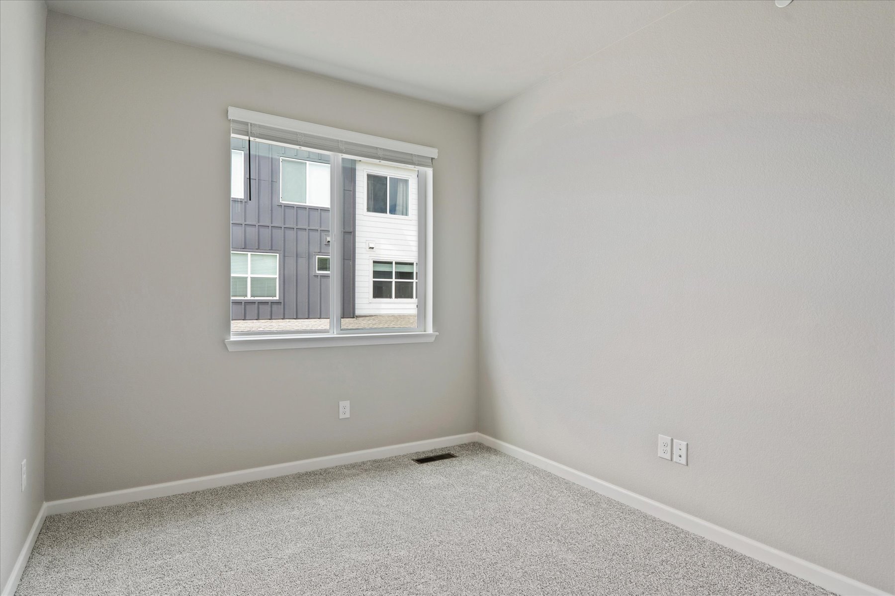 A room with a window and a carpet.
