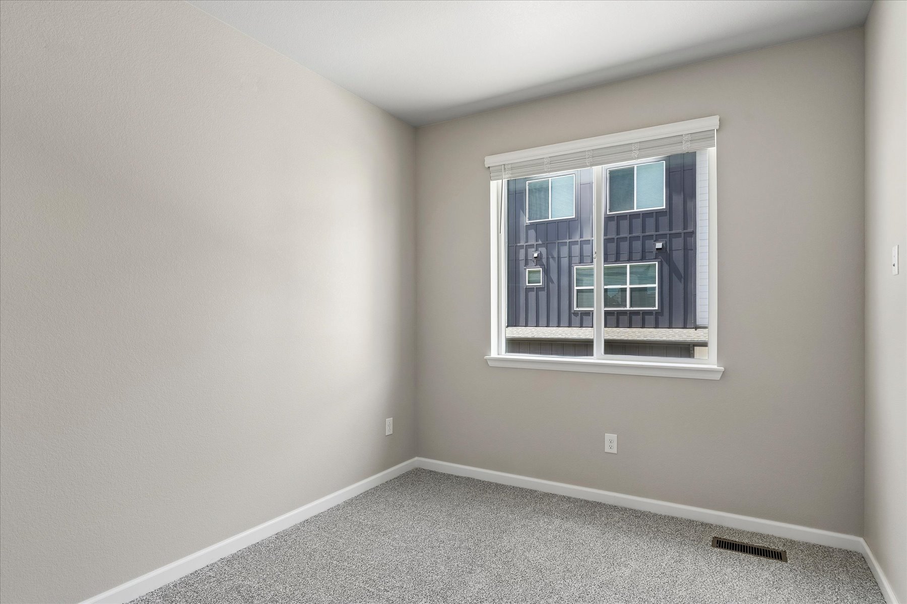 A room with a window and a rug in it.