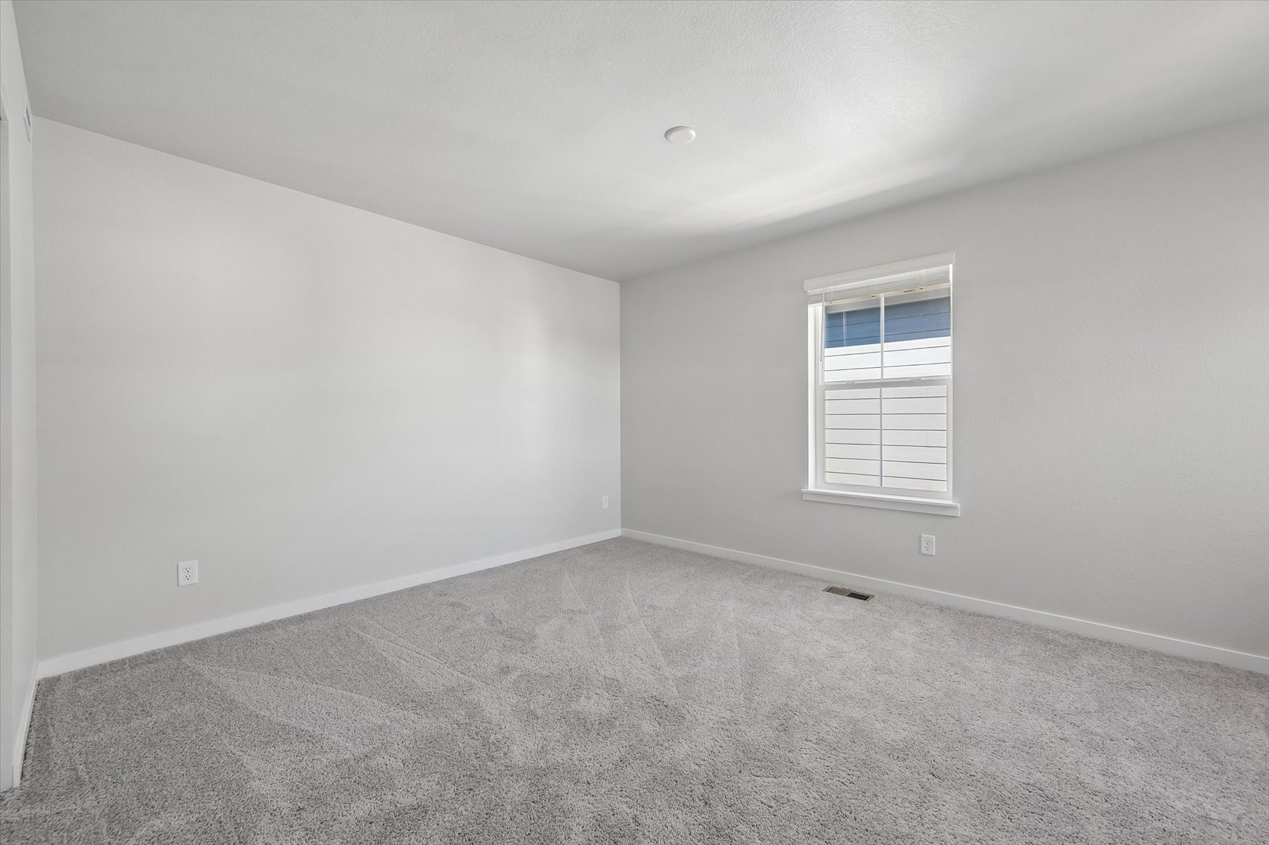 A room with a window and a carpet.