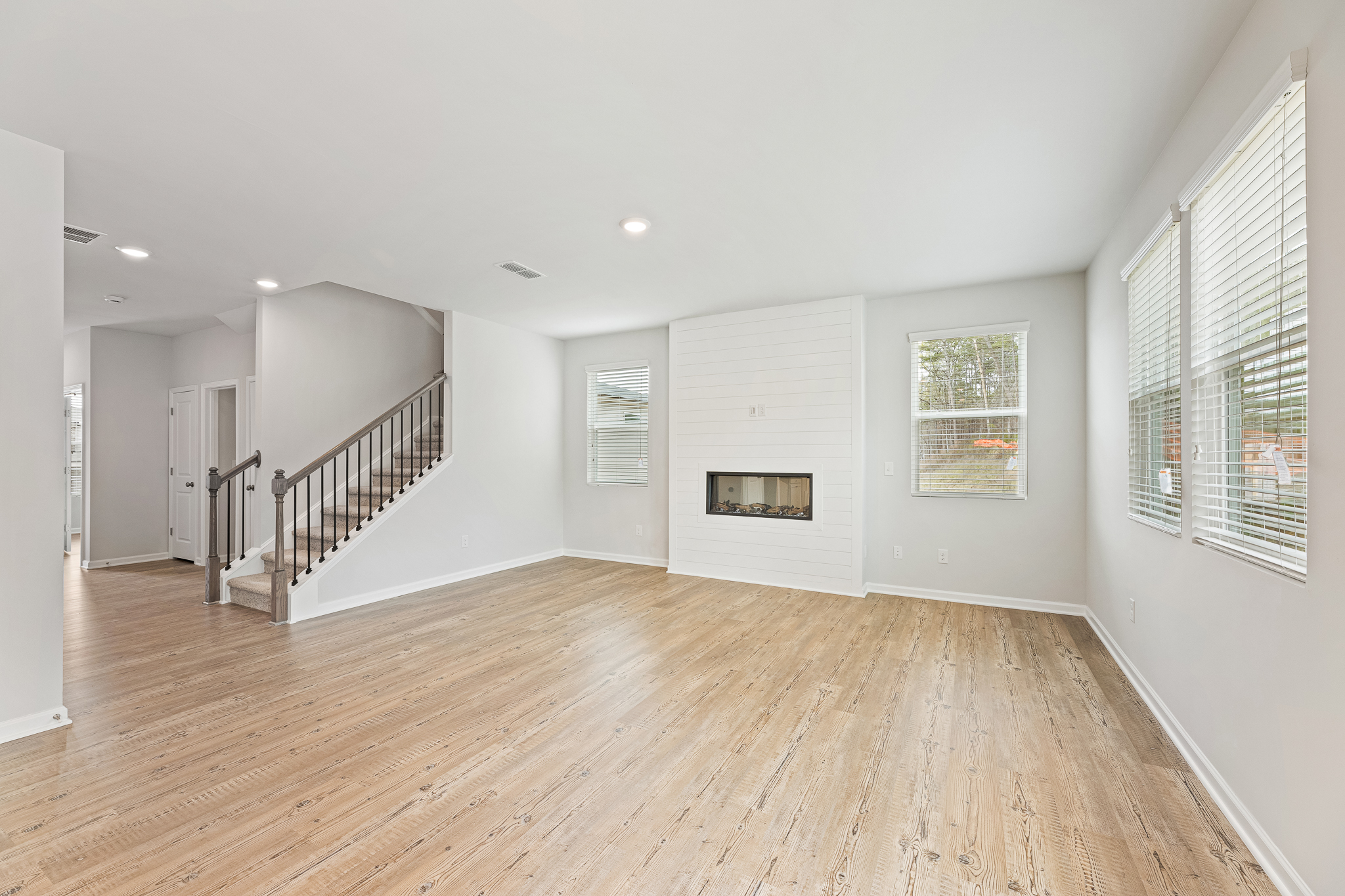 A large empty room with a wood floor and white walls.