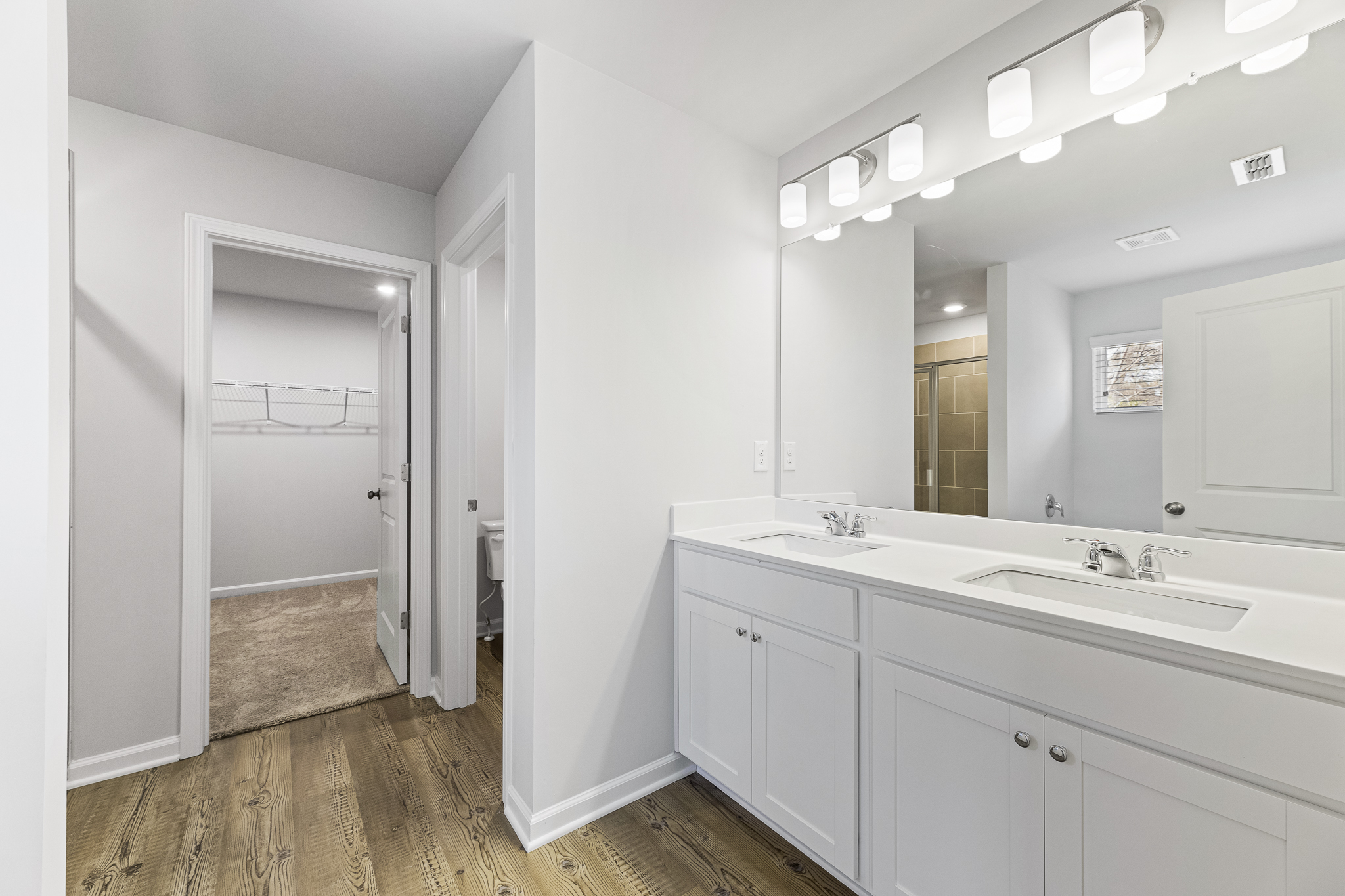 A bathroom with white cabinets.