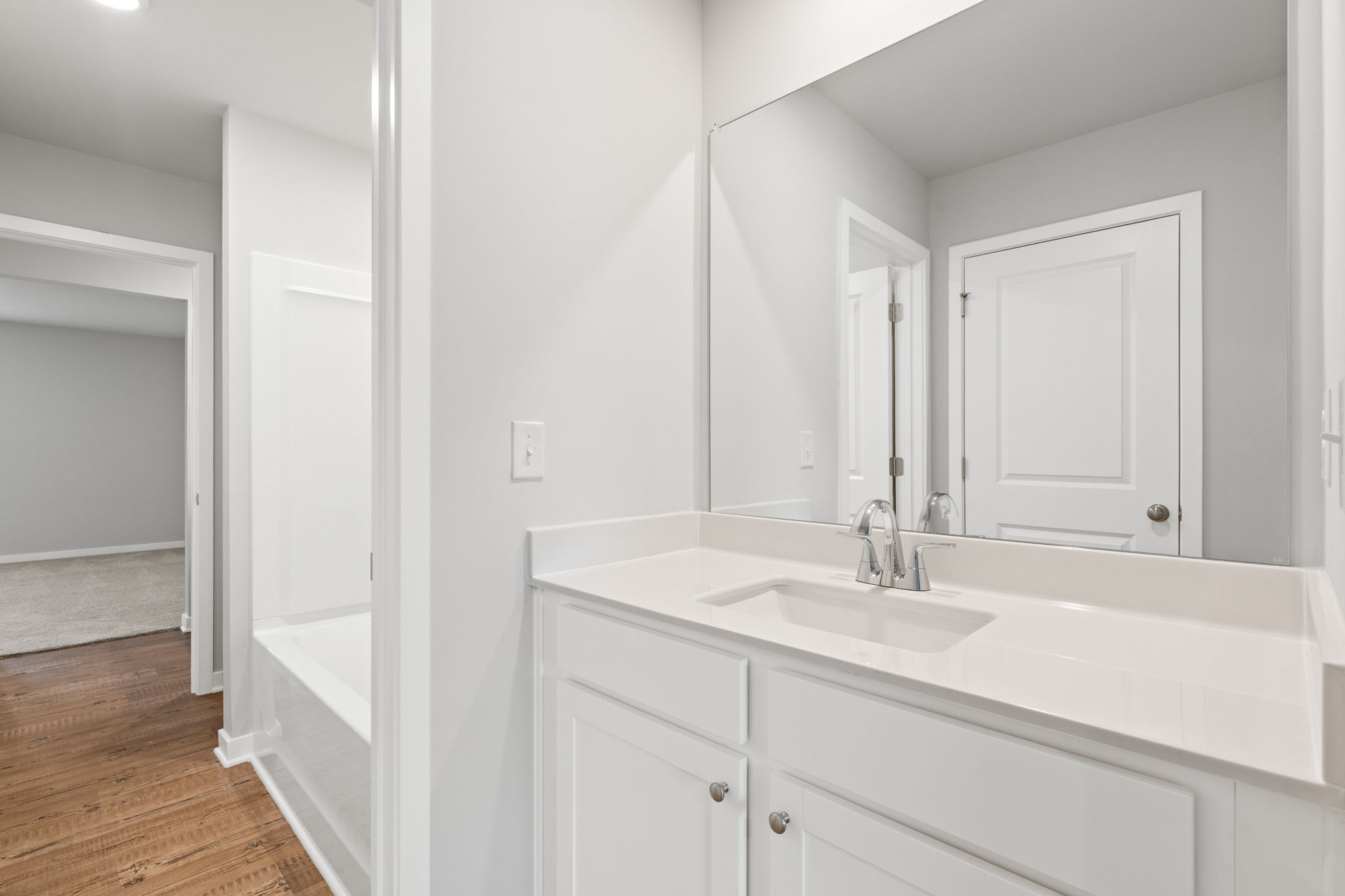 A bathroom with white cabinets.