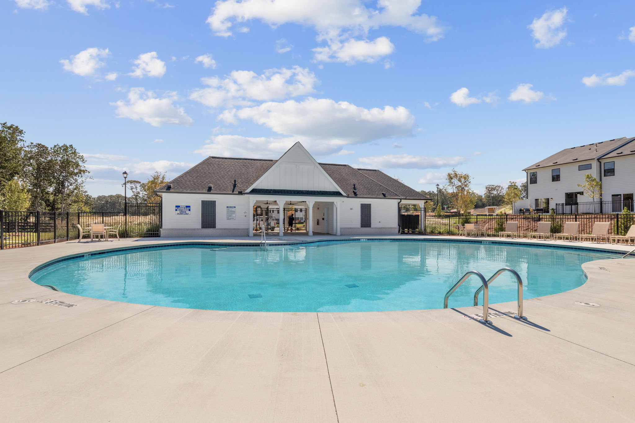A swimming pool in front of a house.