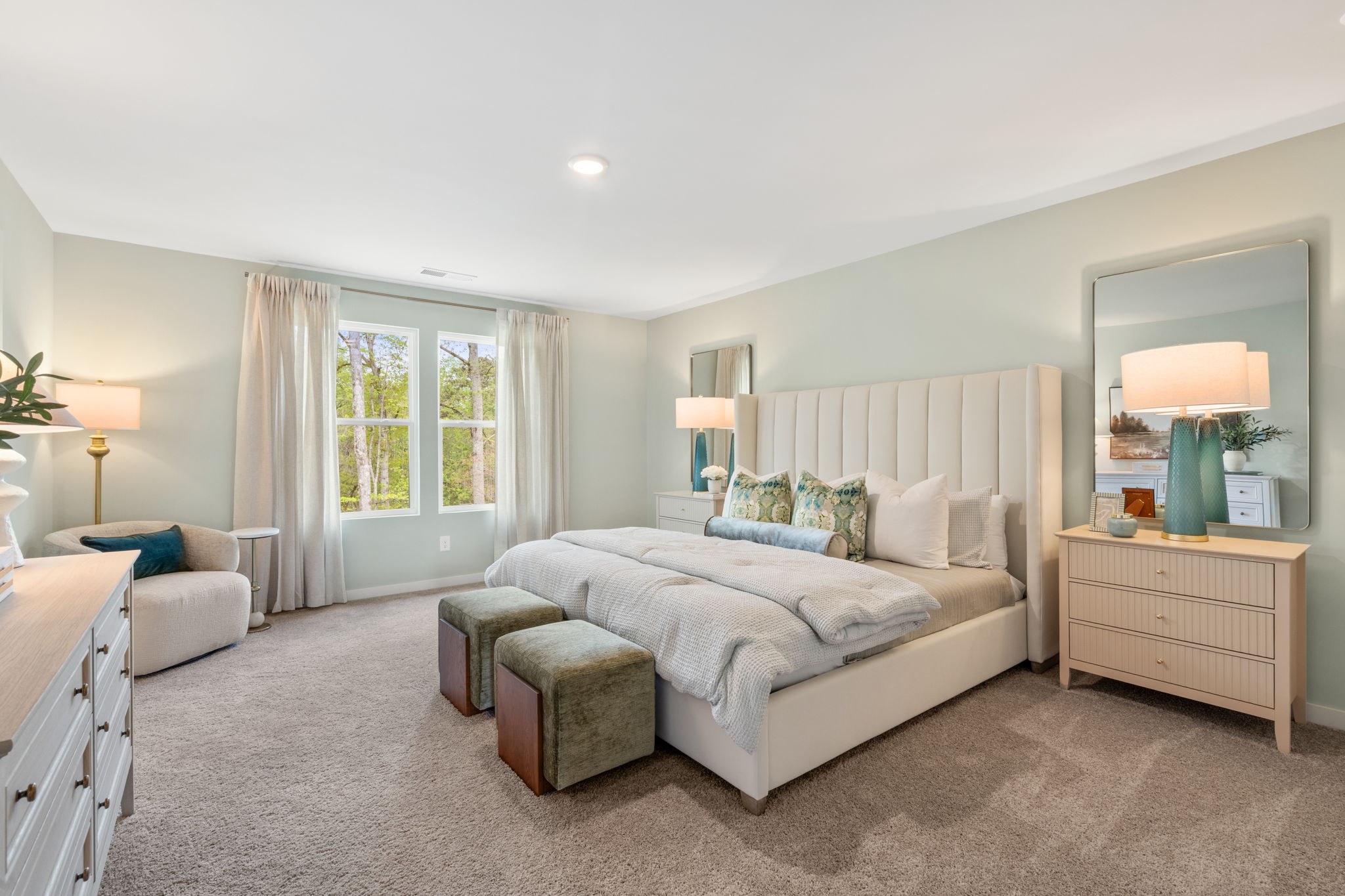 A bedroom with a bed and a mirror.