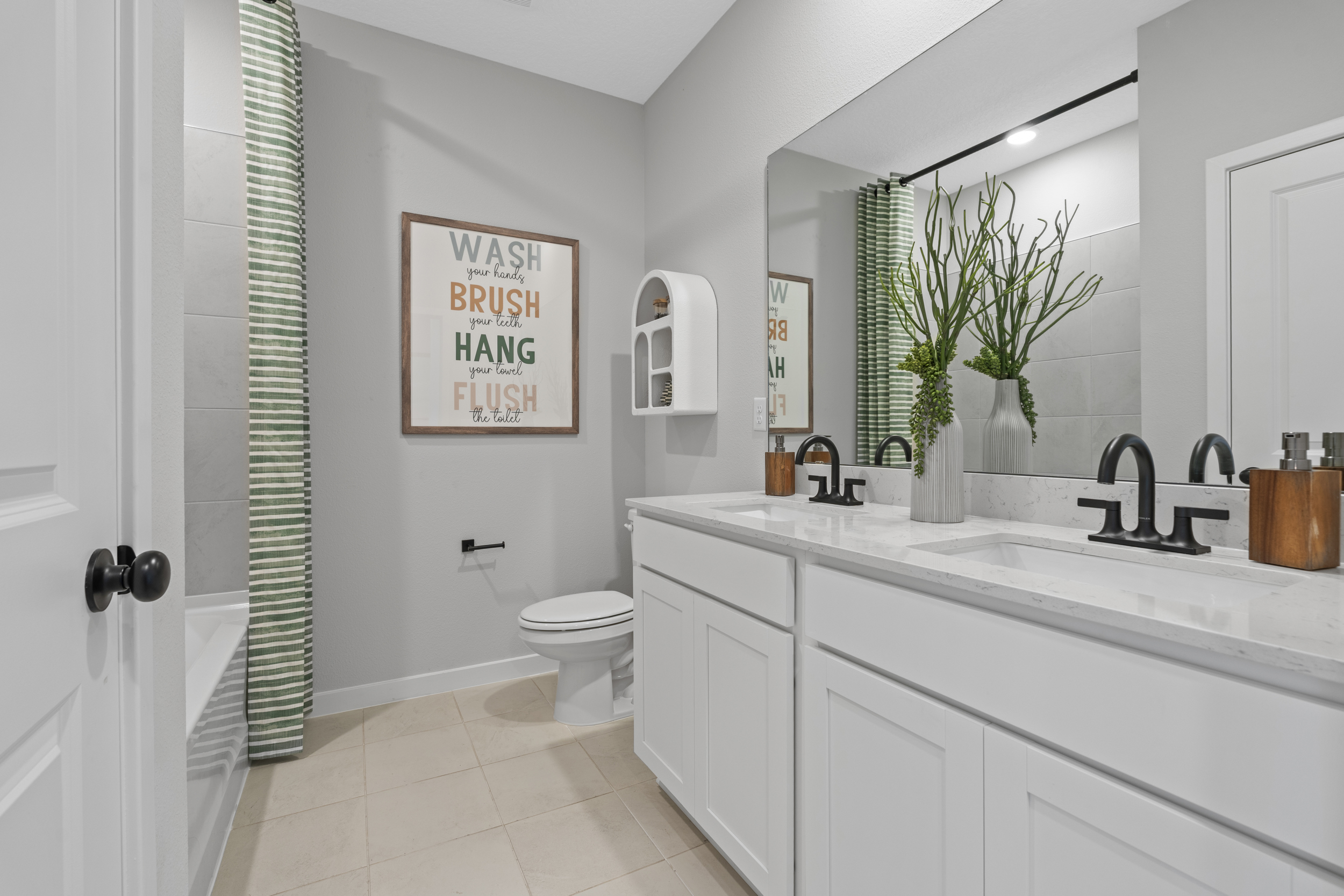 A bathroom with a sink toilet and a mirror.