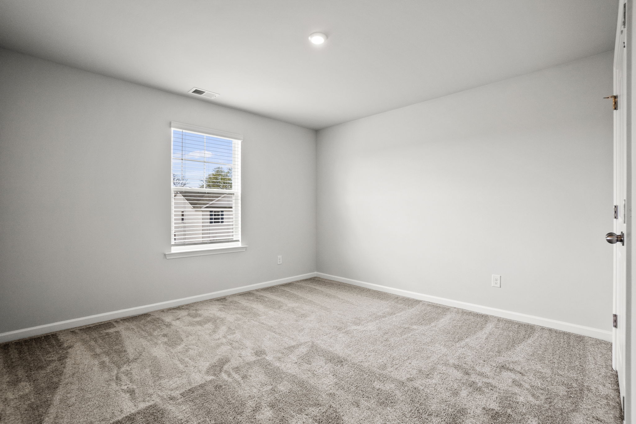 A room with a window and carpet.