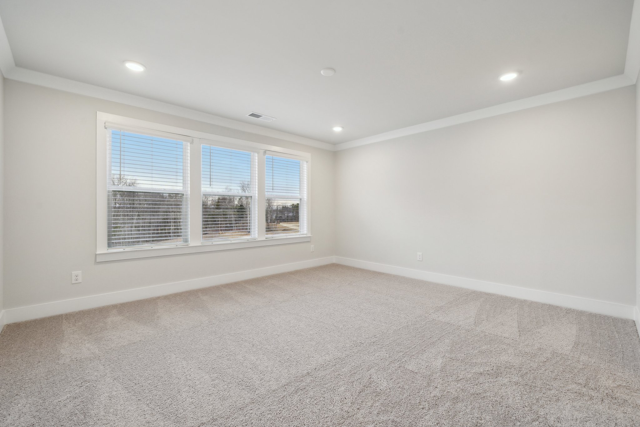 A room with a window and a carpet.