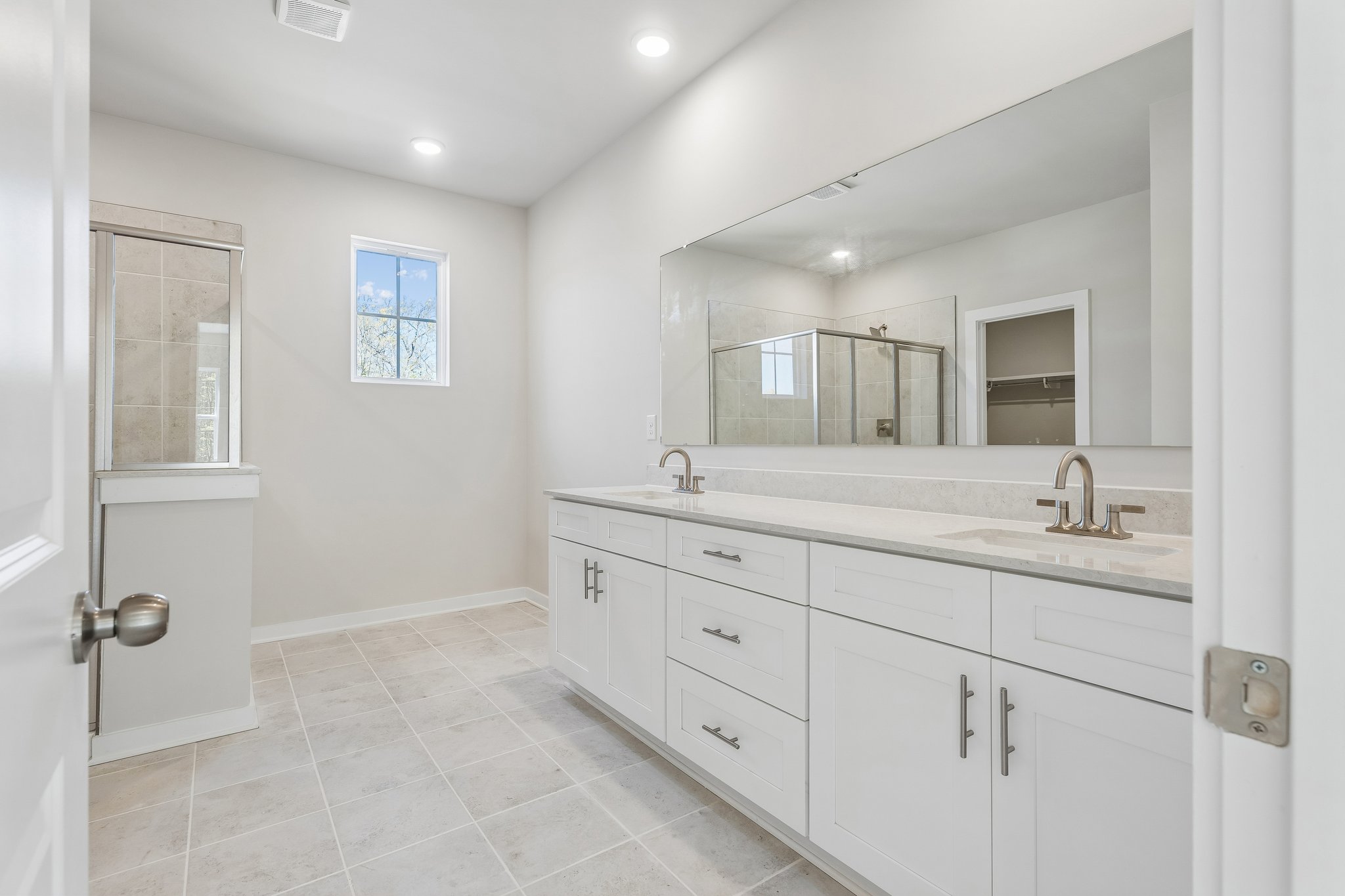 A bathroom with white cabinets.