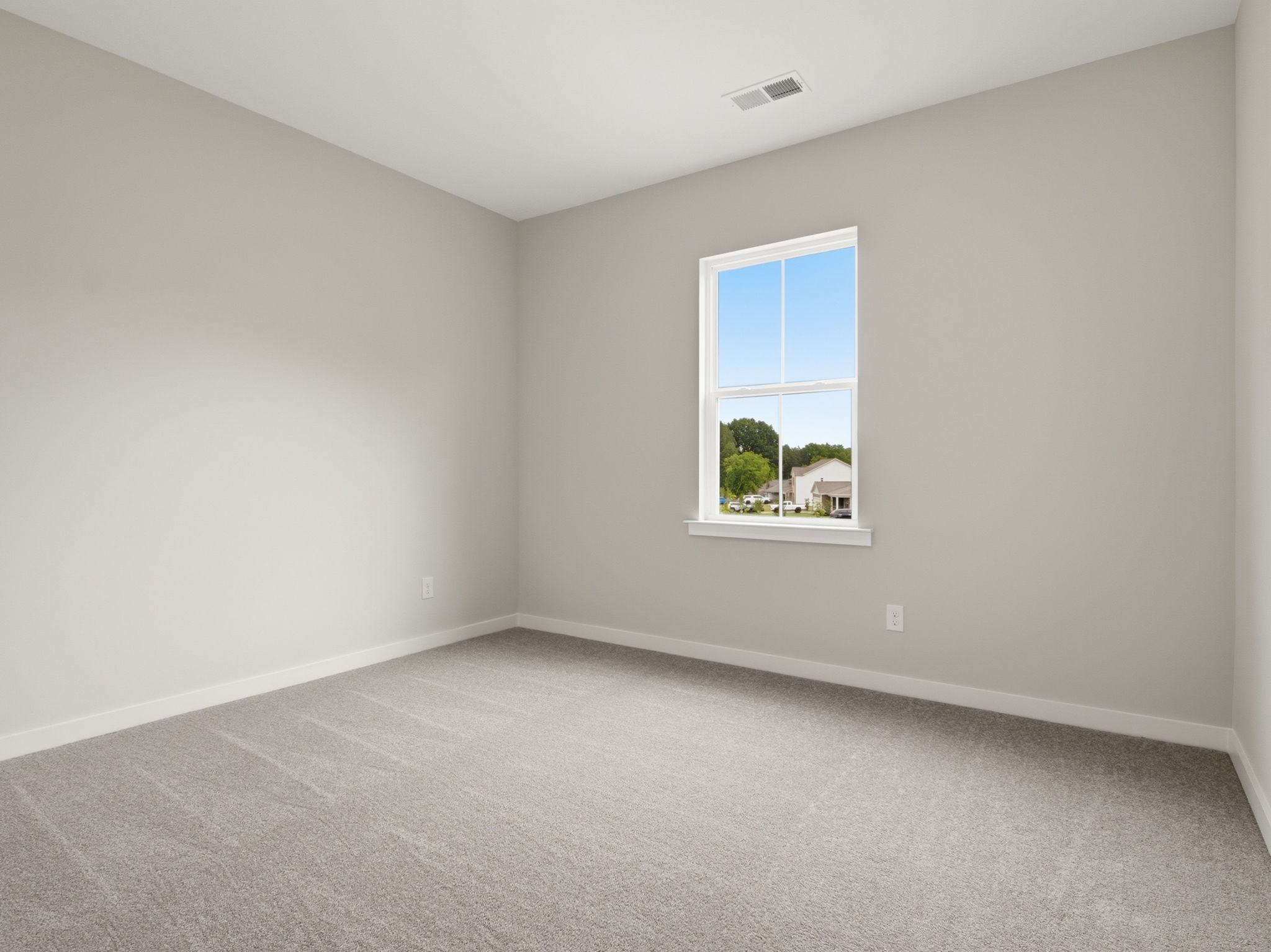A room with a window and carpet.