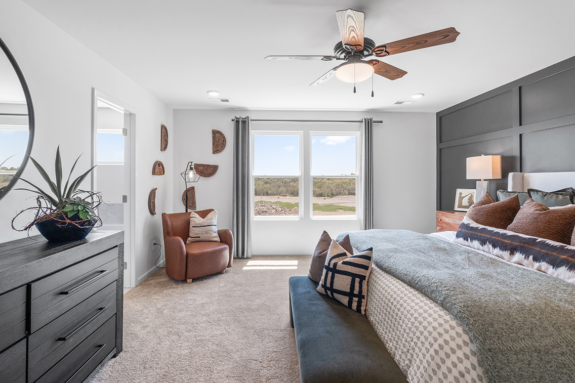 A bedroom with a large window.