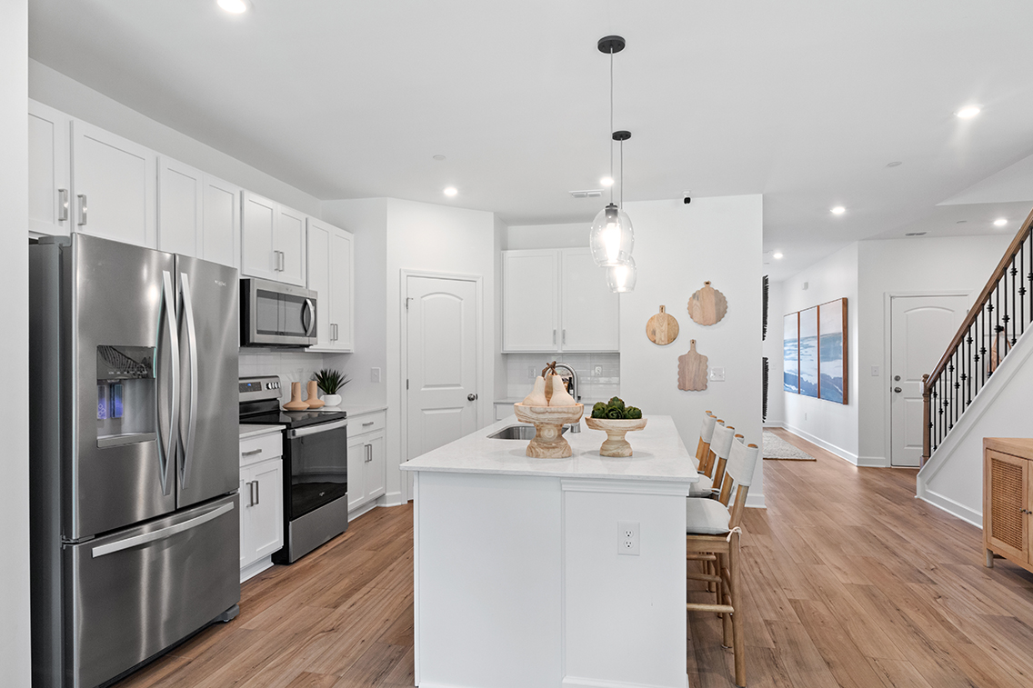 A kitchen with white cabinets.