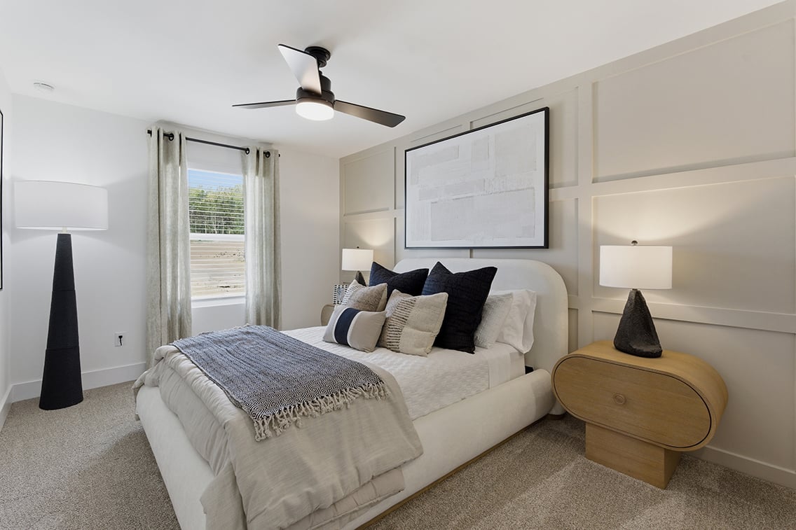 A bedroom with a bed and a table.