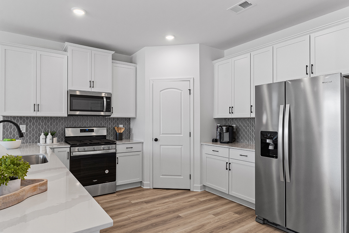 A kitchen with white cabinets.