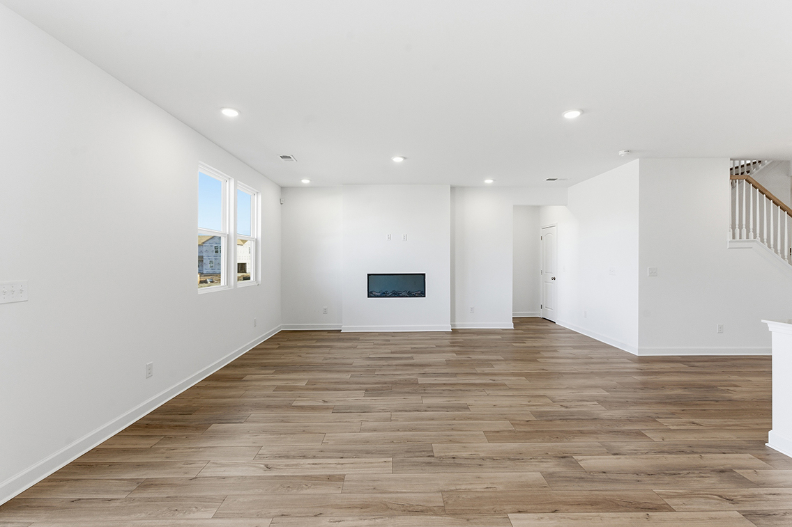A room with white walls and wood floors.