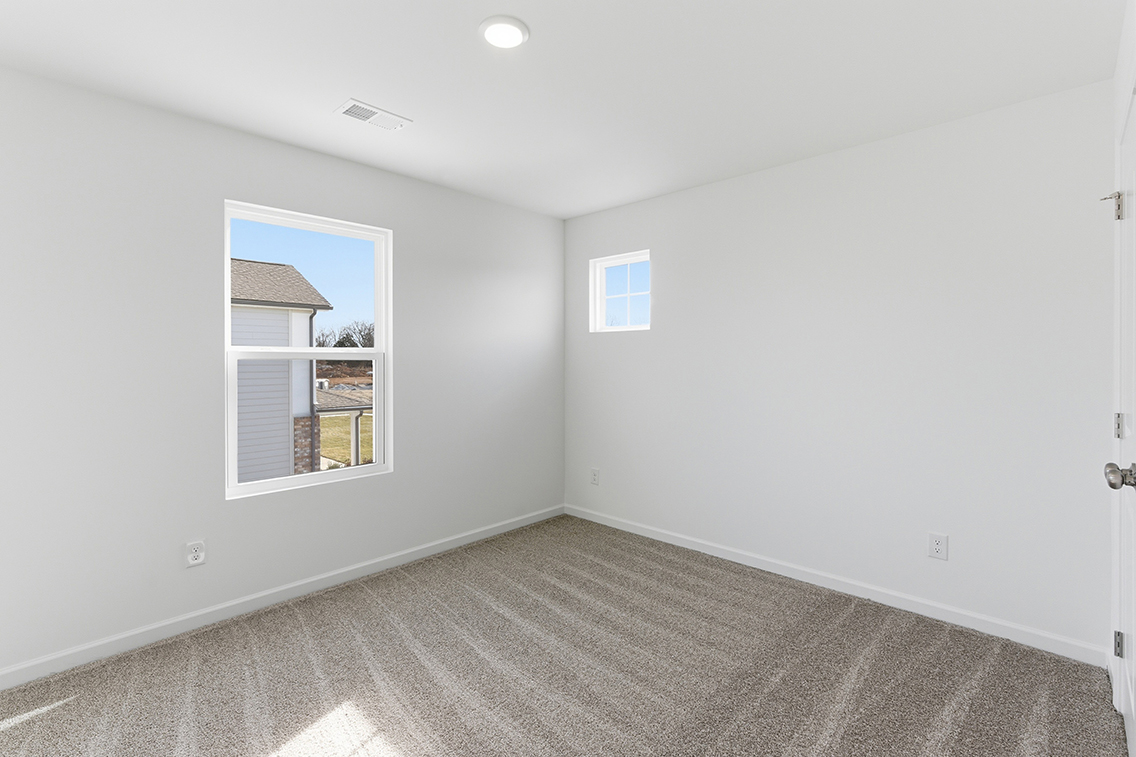 A room with a window and a carpet.