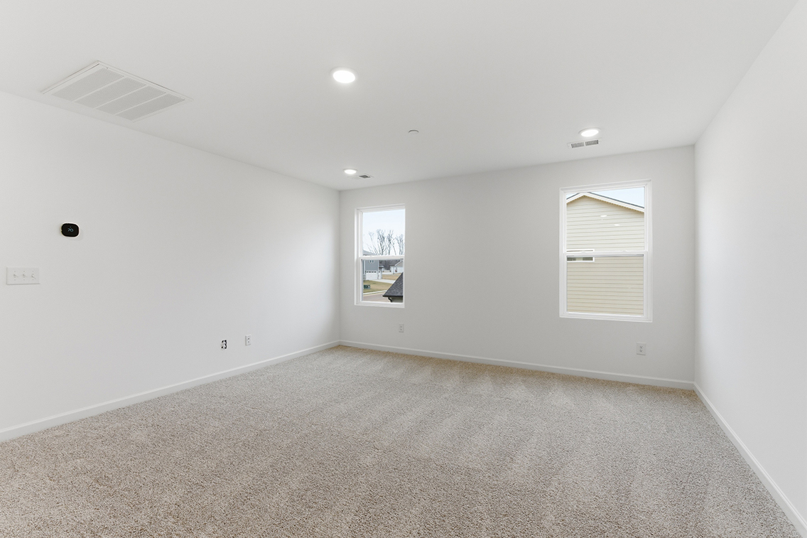 A room with a white wall and a painting on the wall.