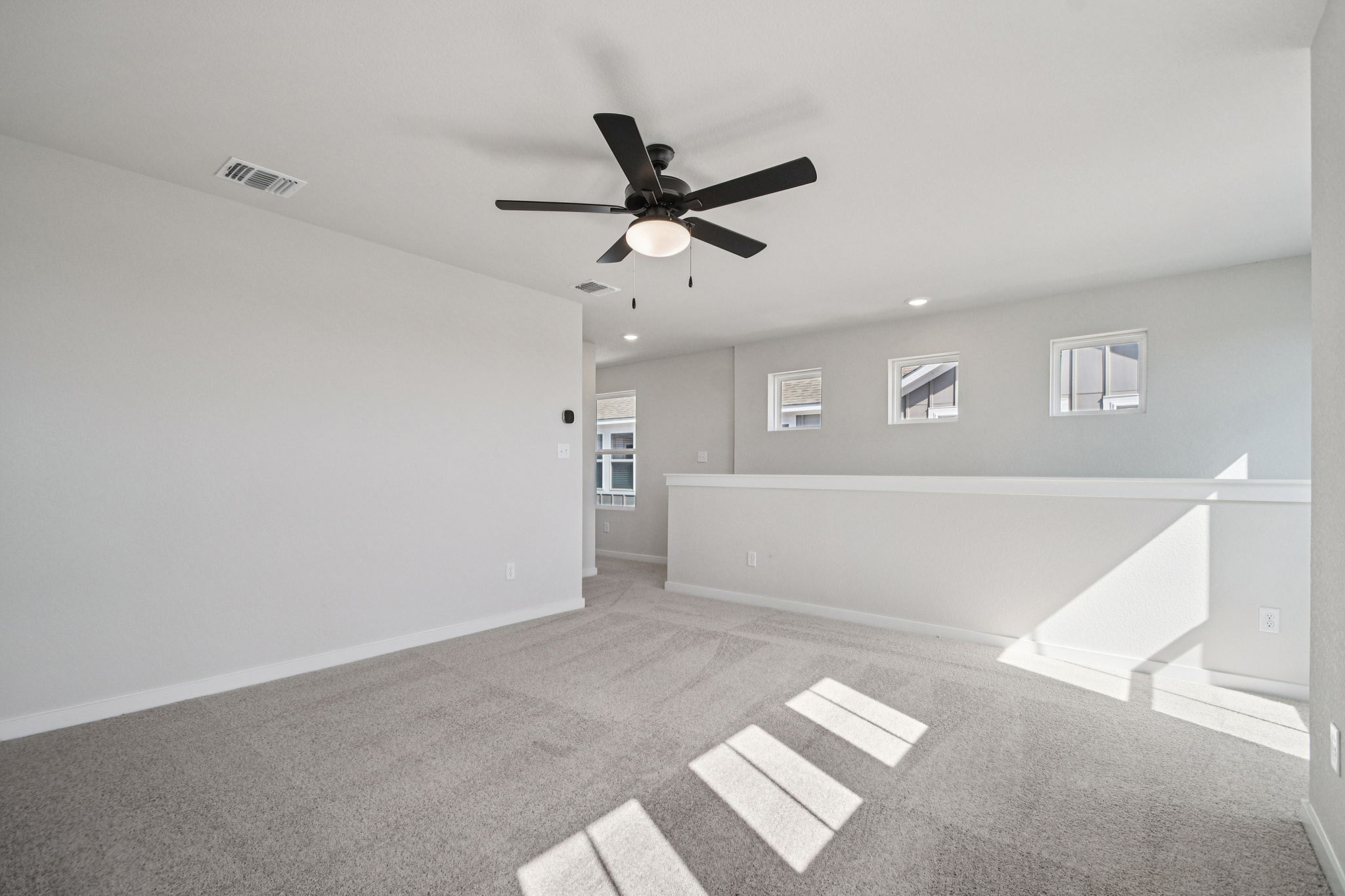 A room with a ceiling fan and a tile floor.
