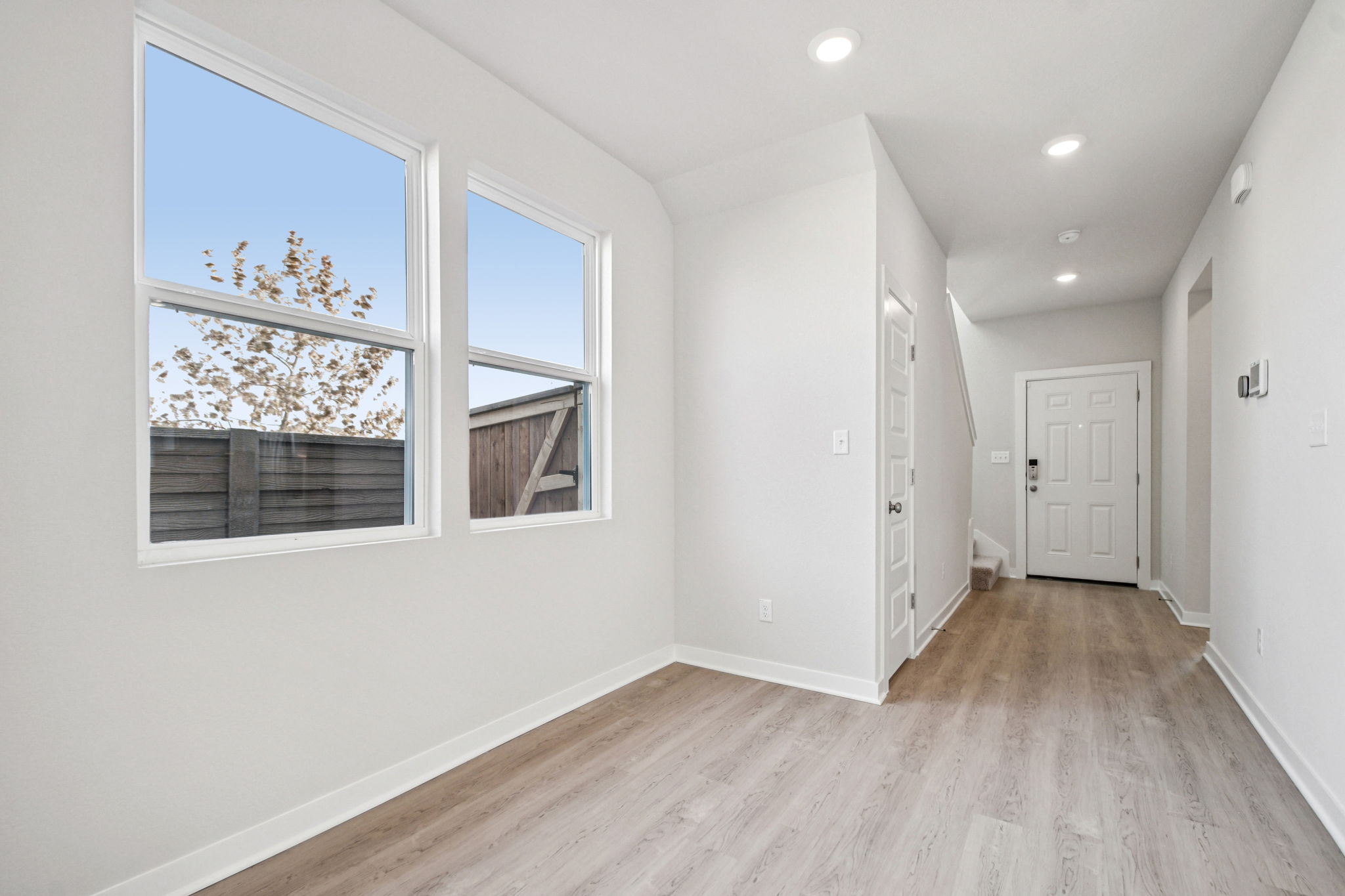 A room with a wood floor and windows.