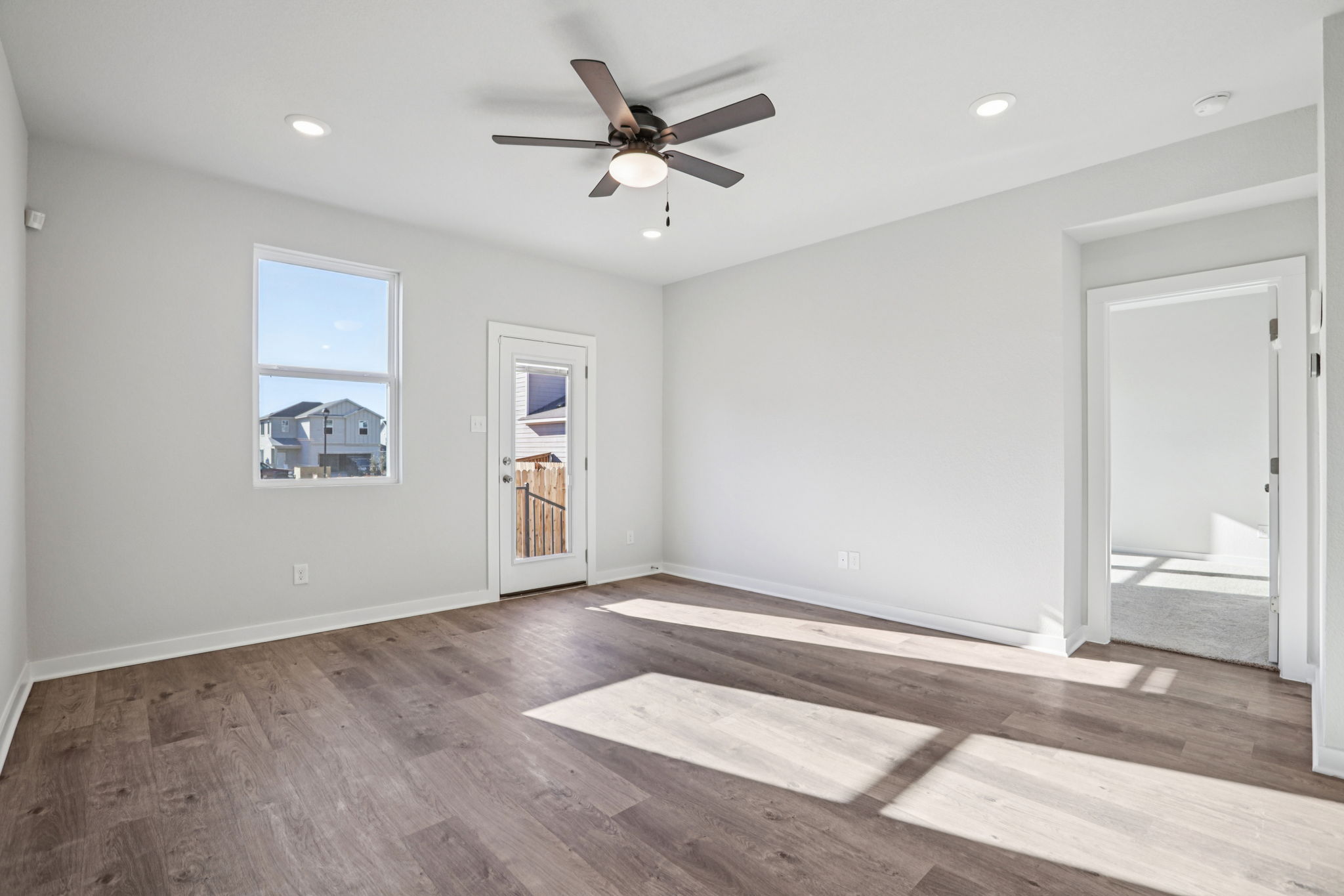 A room with a wood floor and a ceiling fan.