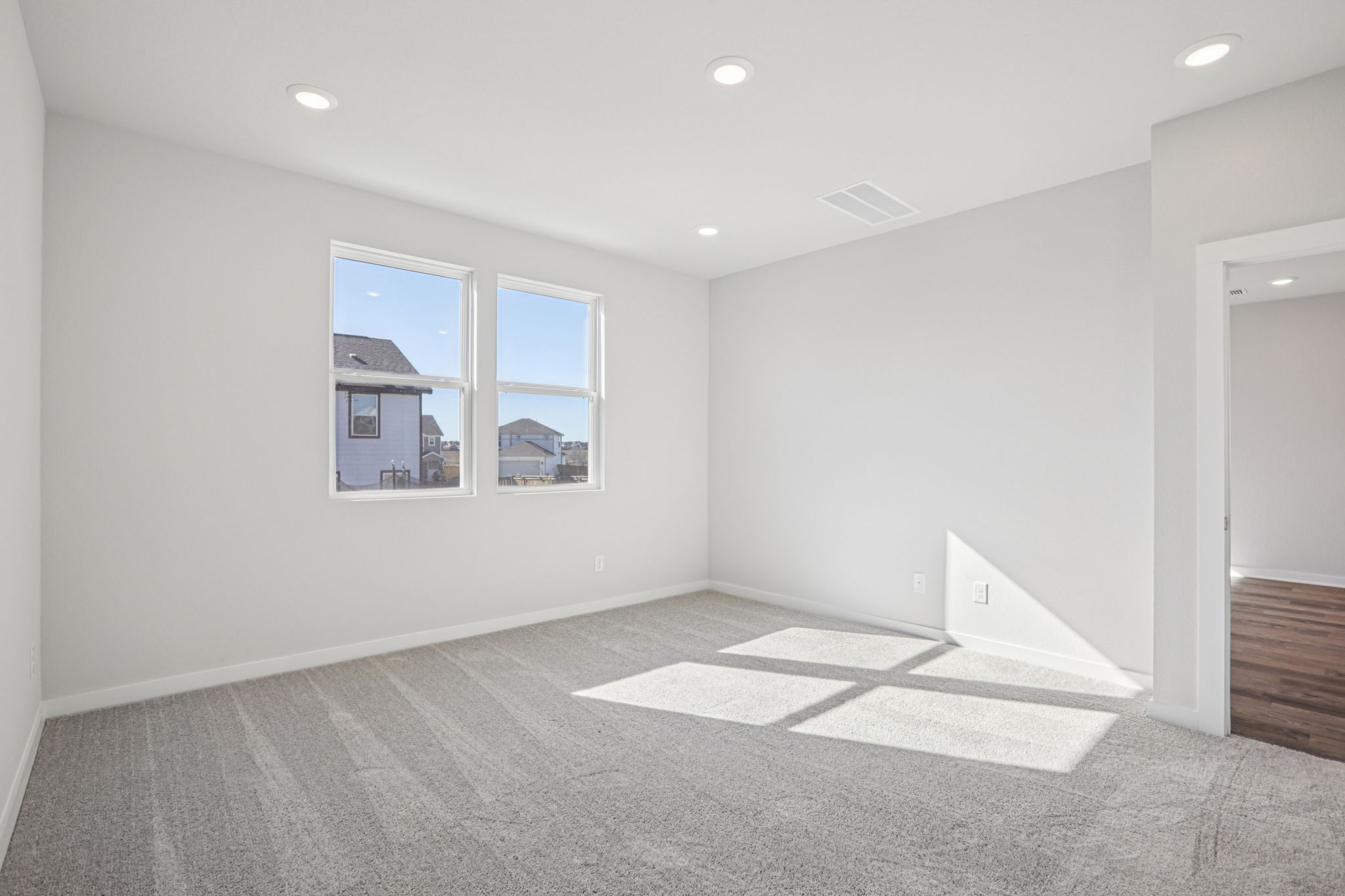 A room with a window and a rug.