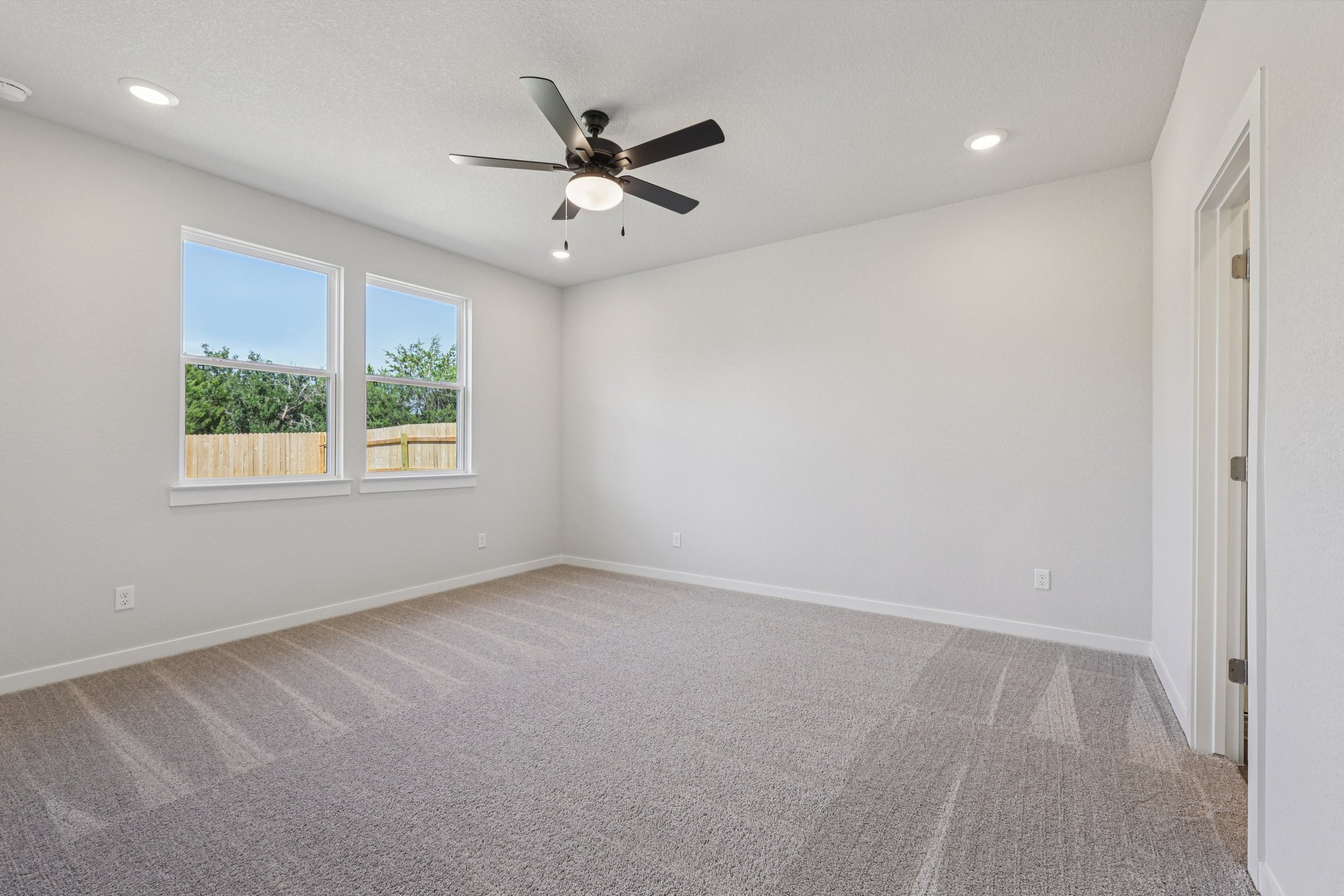 A room with a ceiling fan and a window.