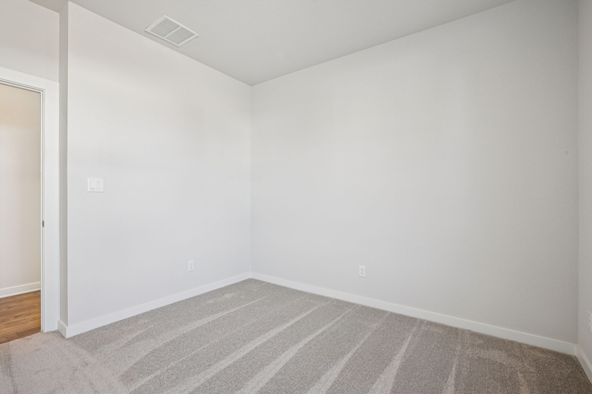 A room with a carpet and a rug.