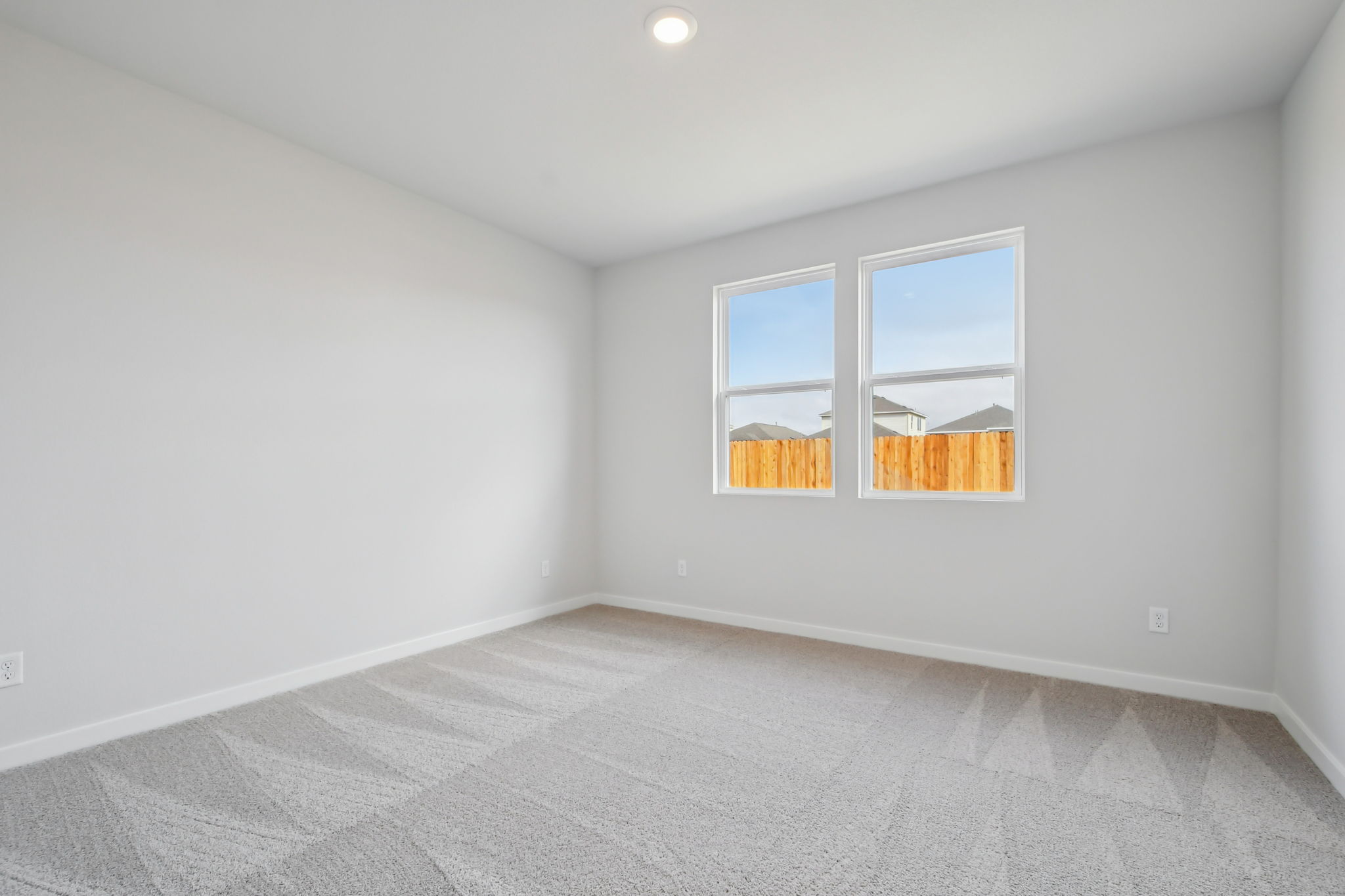 A room with a window and a white wall.